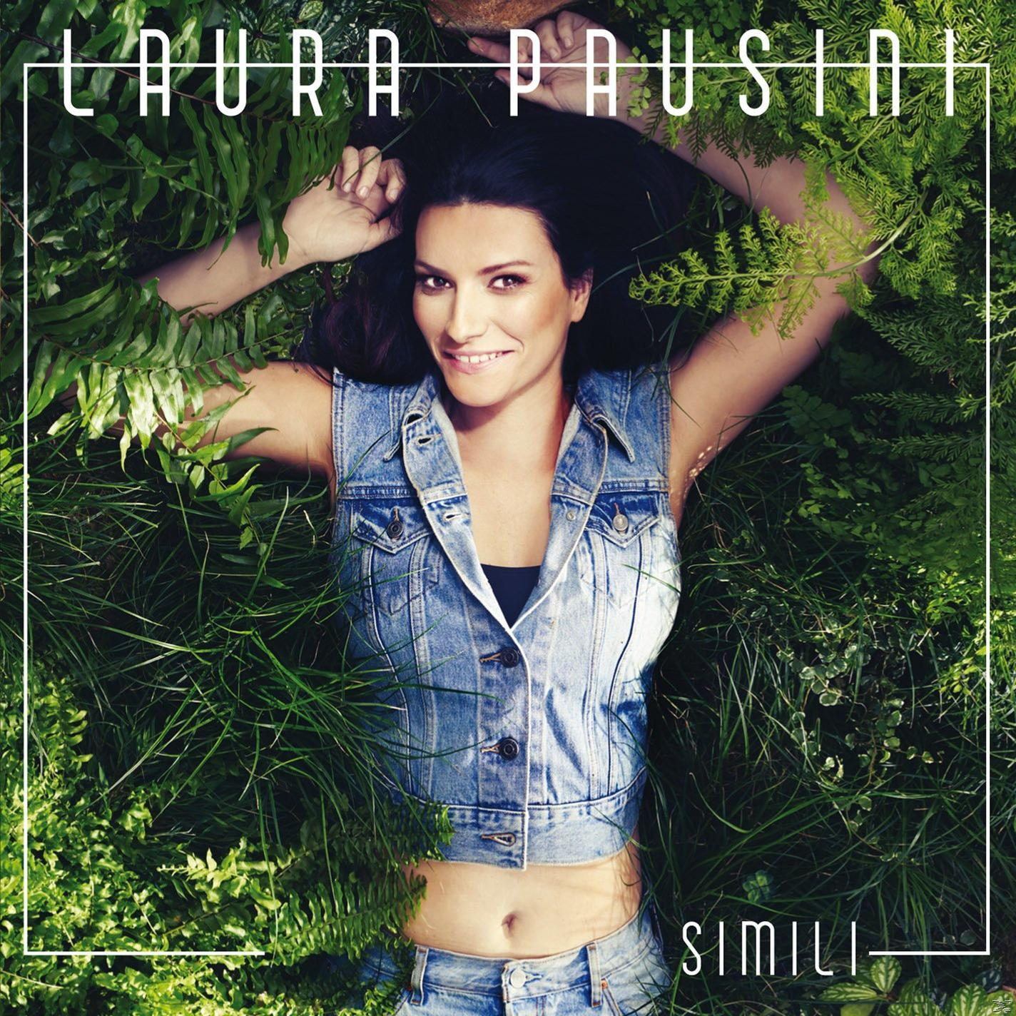 Laura Pausini zöldben fekszik, farmer mellényben. Cím 'Simili'. Növények: páfrányok, fű. Mosolyog a kamerába.