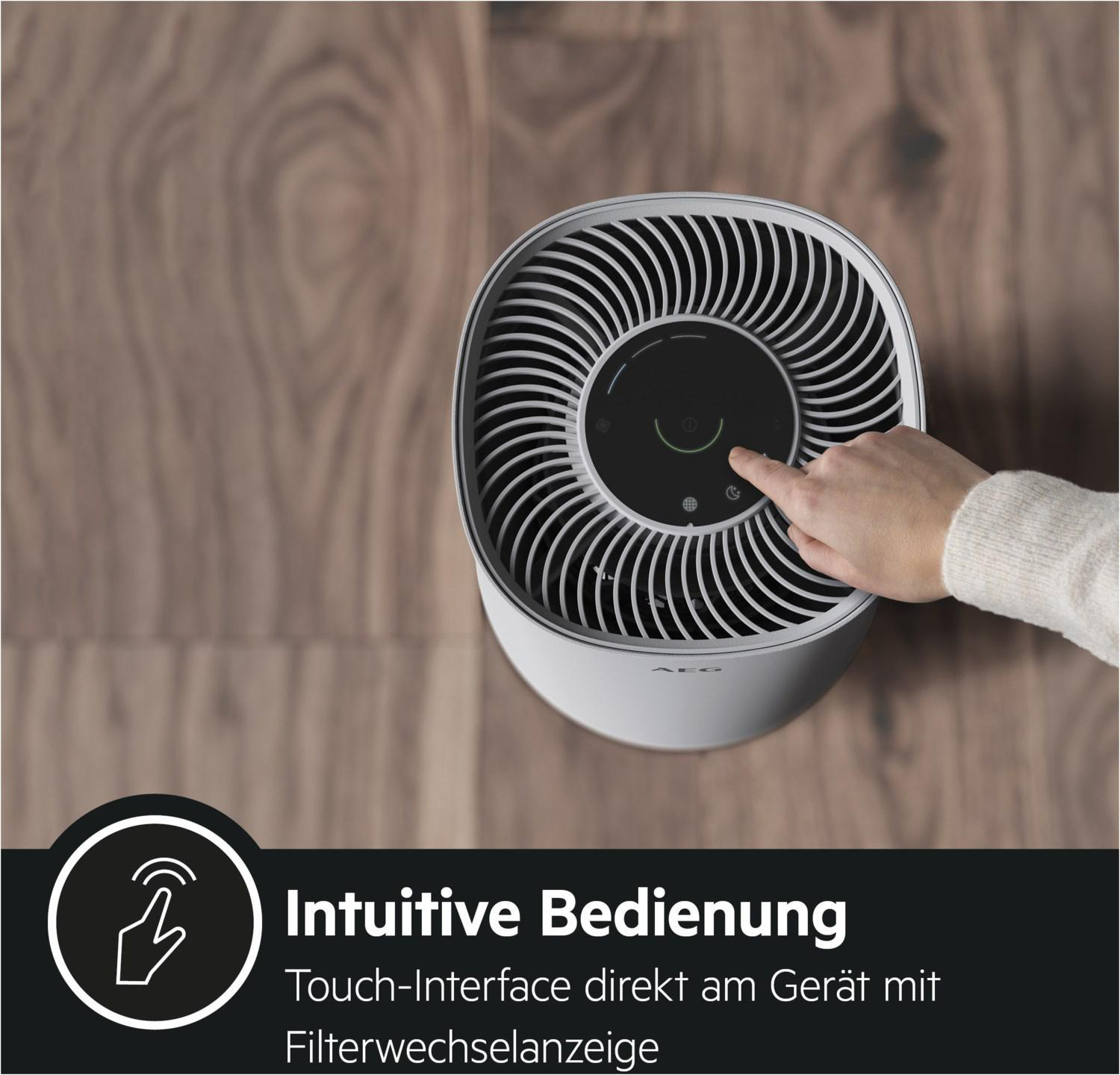Luftreiniger mit einer Hand, die das Bedienfeld berührt.