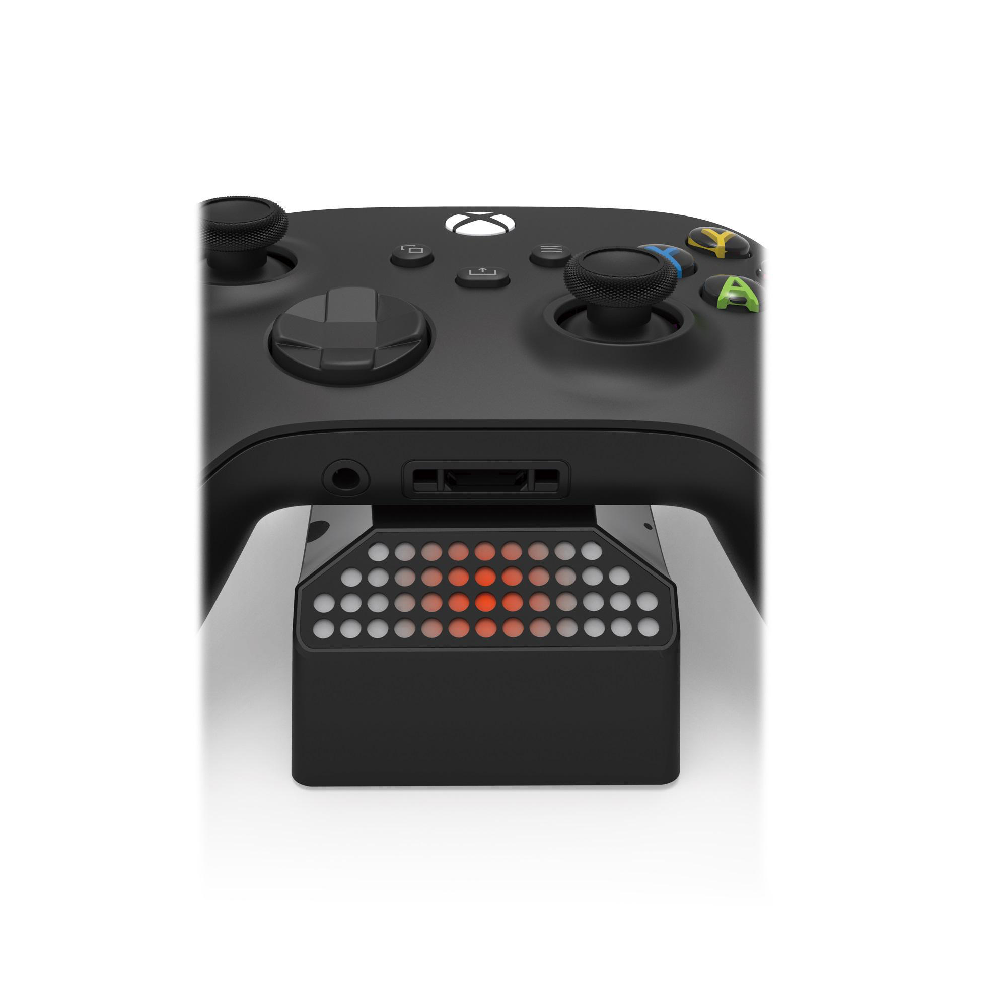 Schwarzer Xbox-Controller auf einer Ladestation. Rote Lichter leuchten auf der Basis.