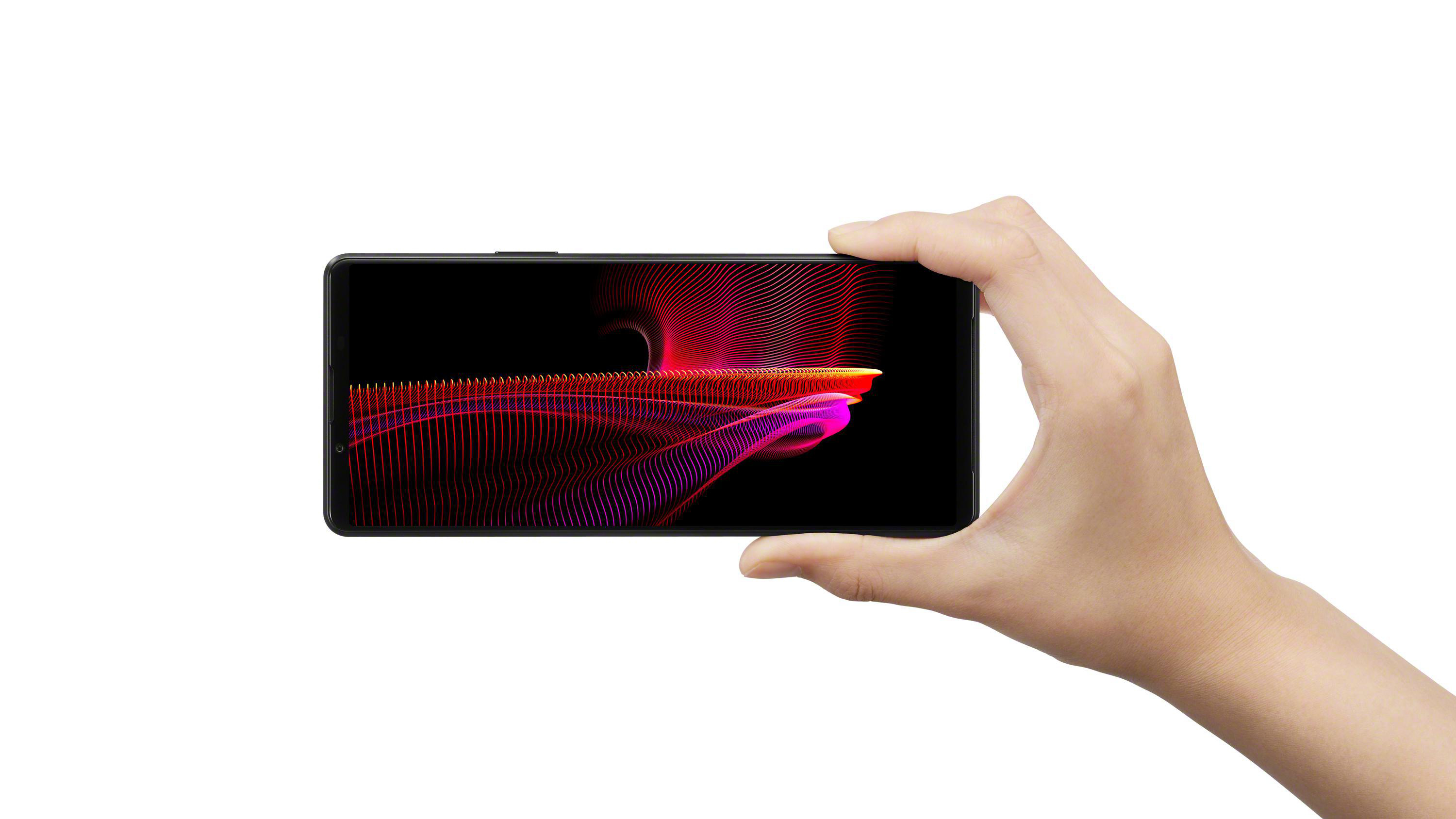 Hand hält Smartphone, Bildschirm zeigt abstraktes, farbenfrohes Muster.
