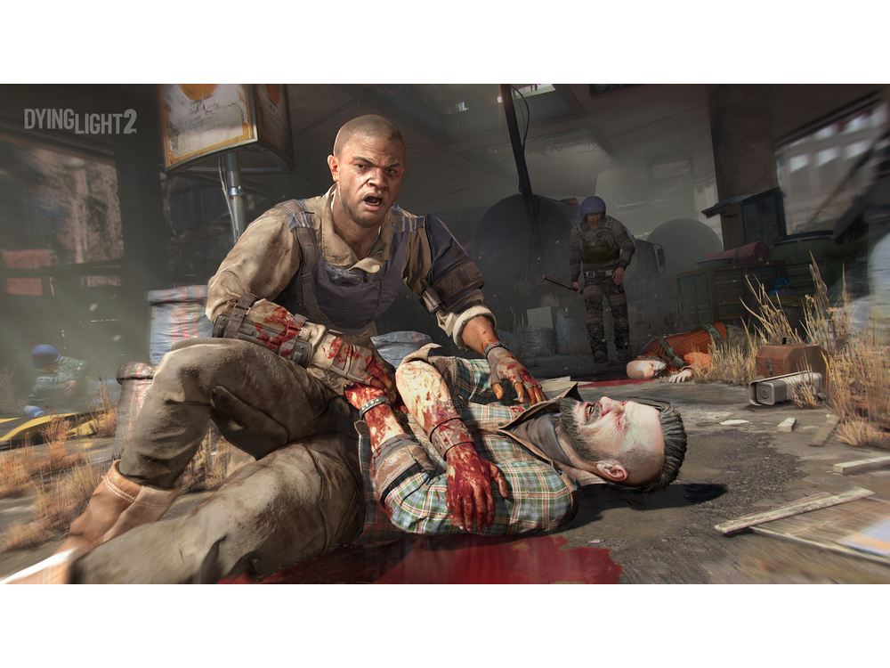 Escena del juego Dying Light 2. Un hombre ayuda a otro hombre en el suelo, ambos cubiertos de sangre.