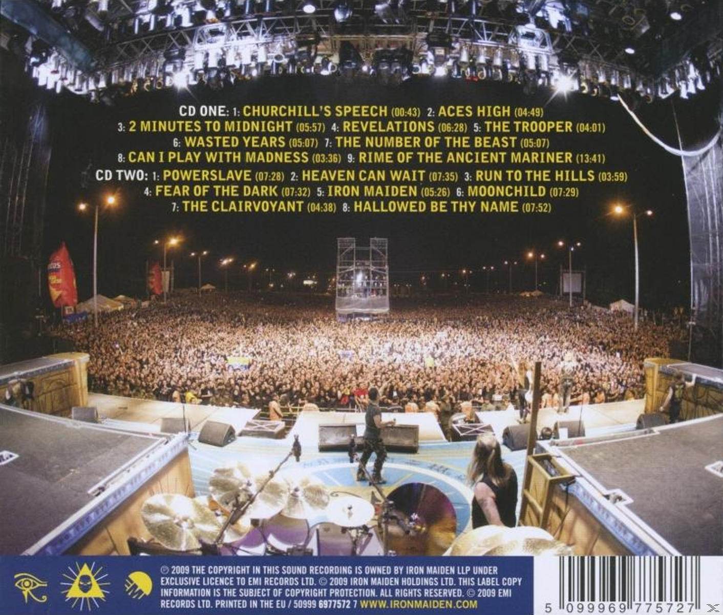 Élő koncertszínpad. Iron Maiden játszik, nagy tömeg. Színpadi fények, felszerelés. Sötét környezet.