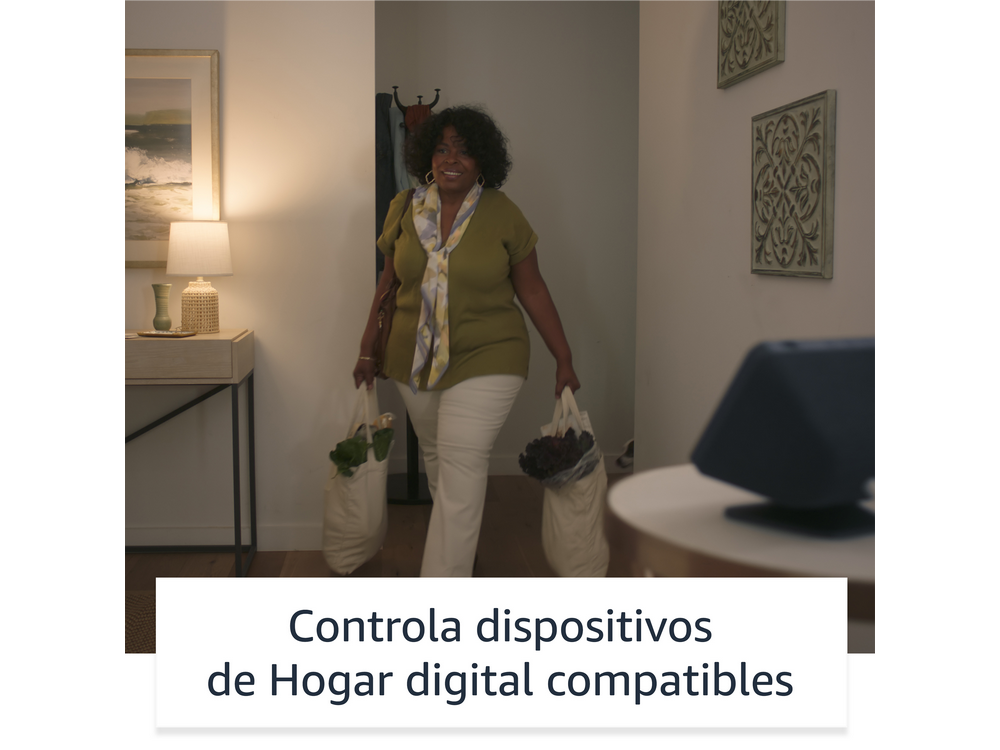 Una mujer que lleva comestibles sonríe en un pasillo bien iluminado.
