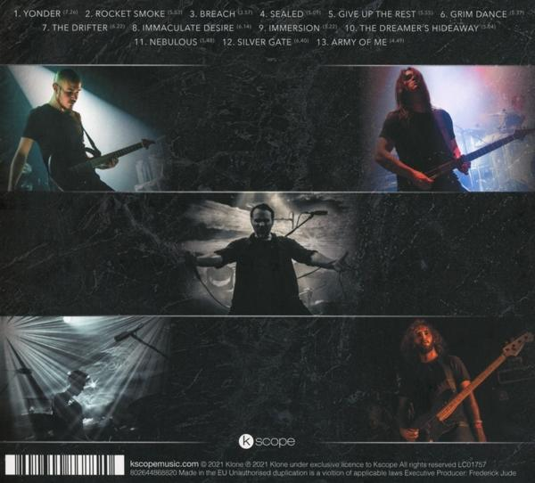 Albumcover mit einer Band und einer Titelliste. Der Hintergrund ist dunkel.