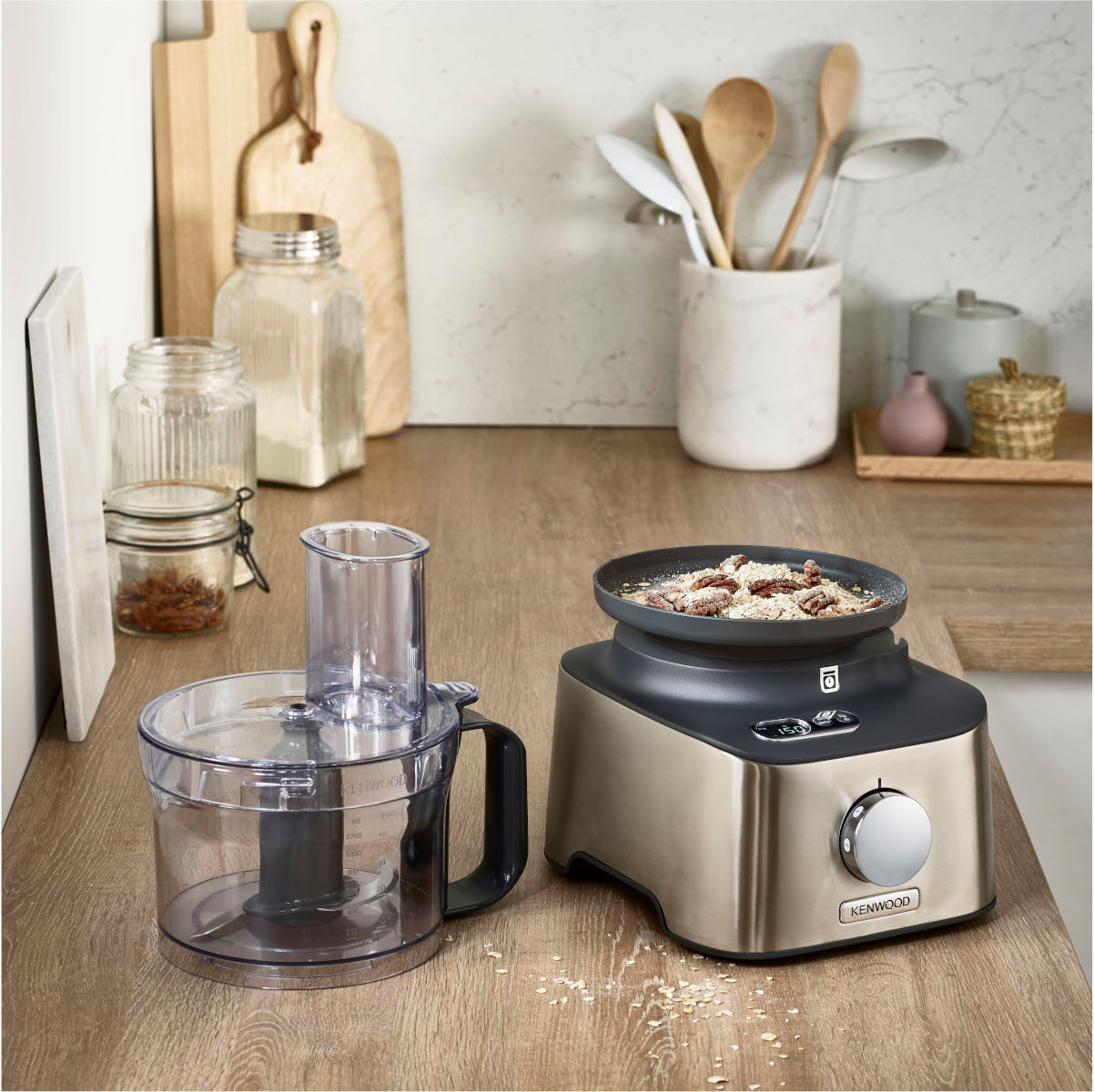 A food processor and other kitchen tools are on a table.