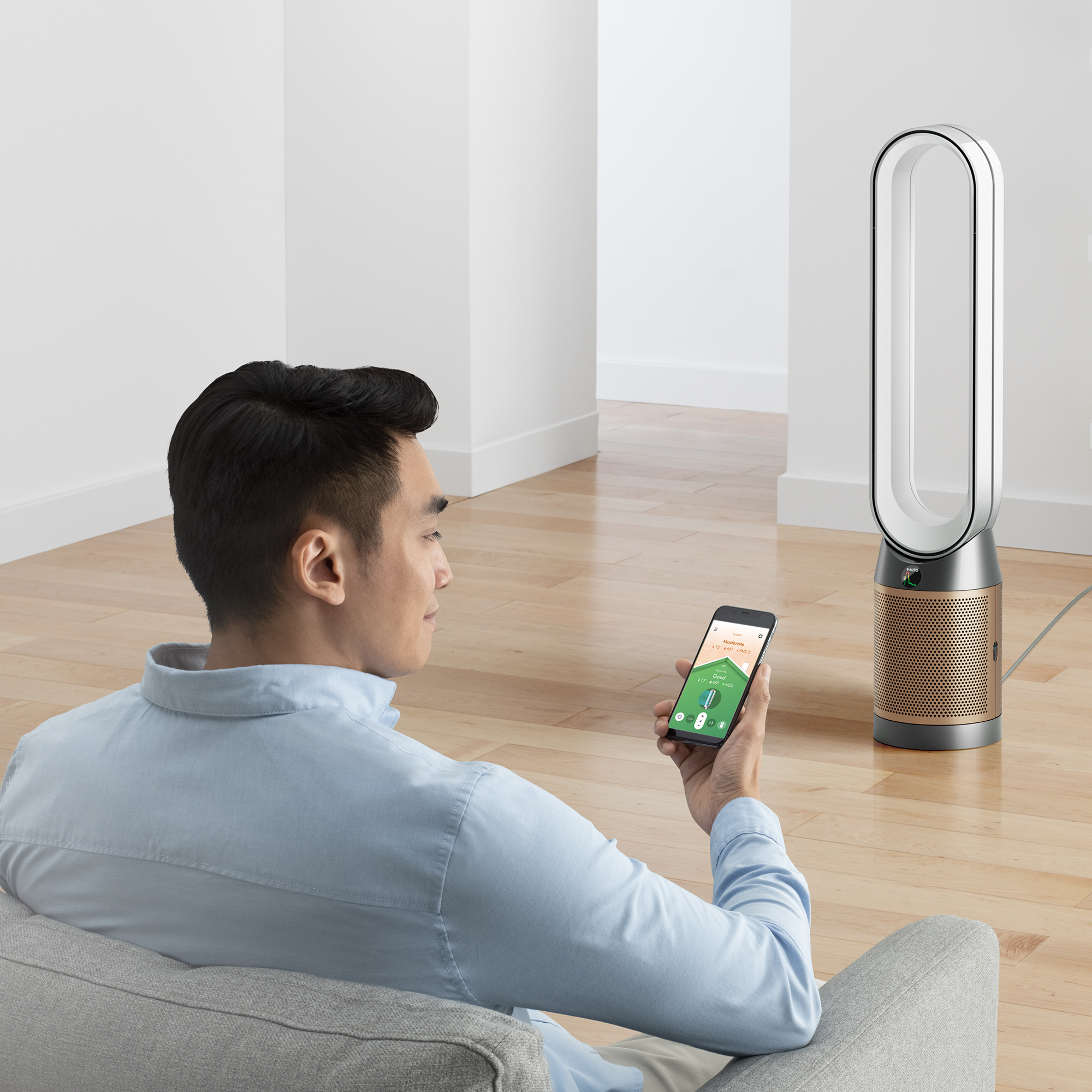 Man gebruikt smartphone om een ventilator te bedienen. De ventilator staat op de achtergrond.