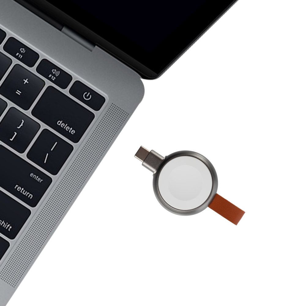 Laptop-Tastatur mit einem Uhrenladegerät. Weißer Hintergrund.