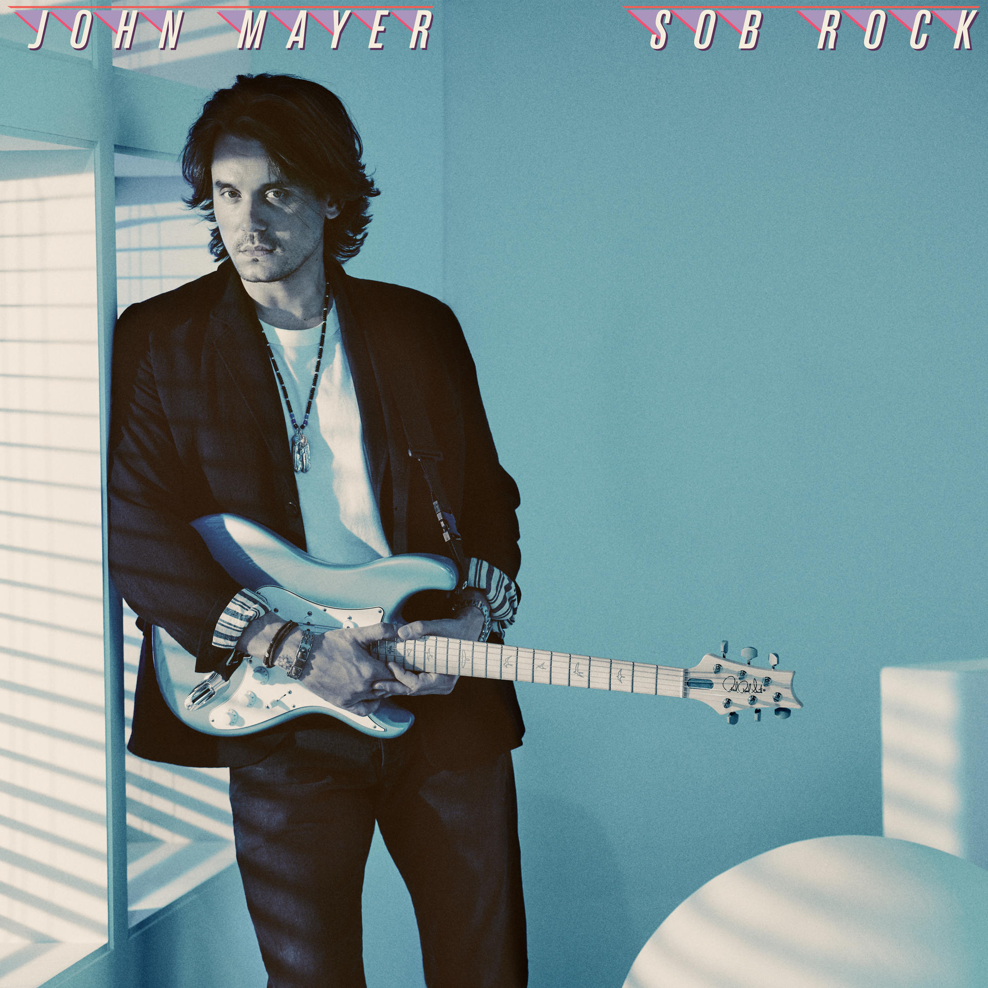 John Mayer steht mit Gitarre an der Wand. Der Albumname ist 'Sob Rock'.
