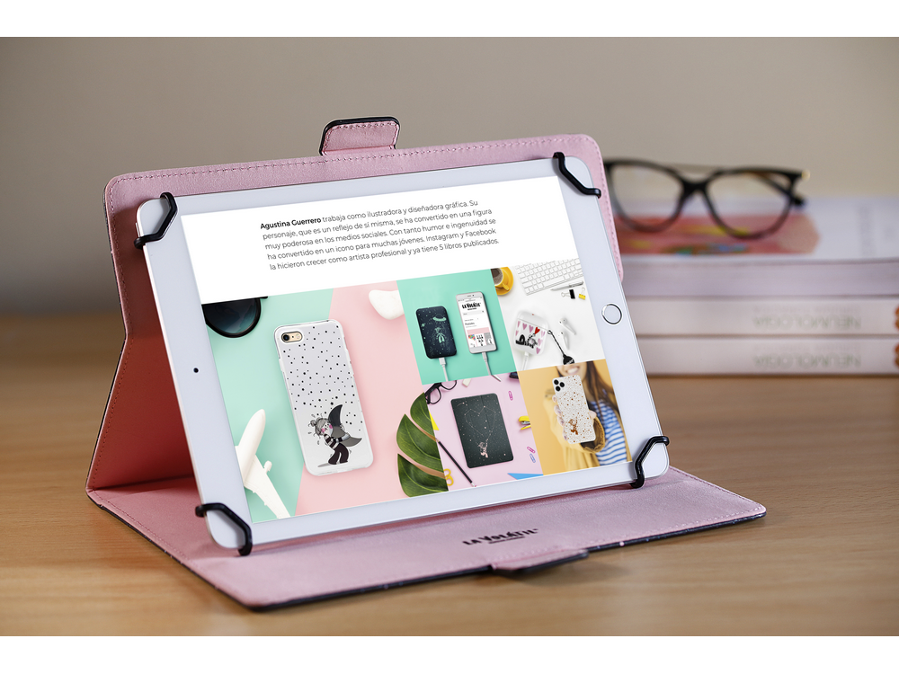Tableta en una funda rosa, abierta sobre un escritorio. Texto e imágenes visibles en la pantalla.