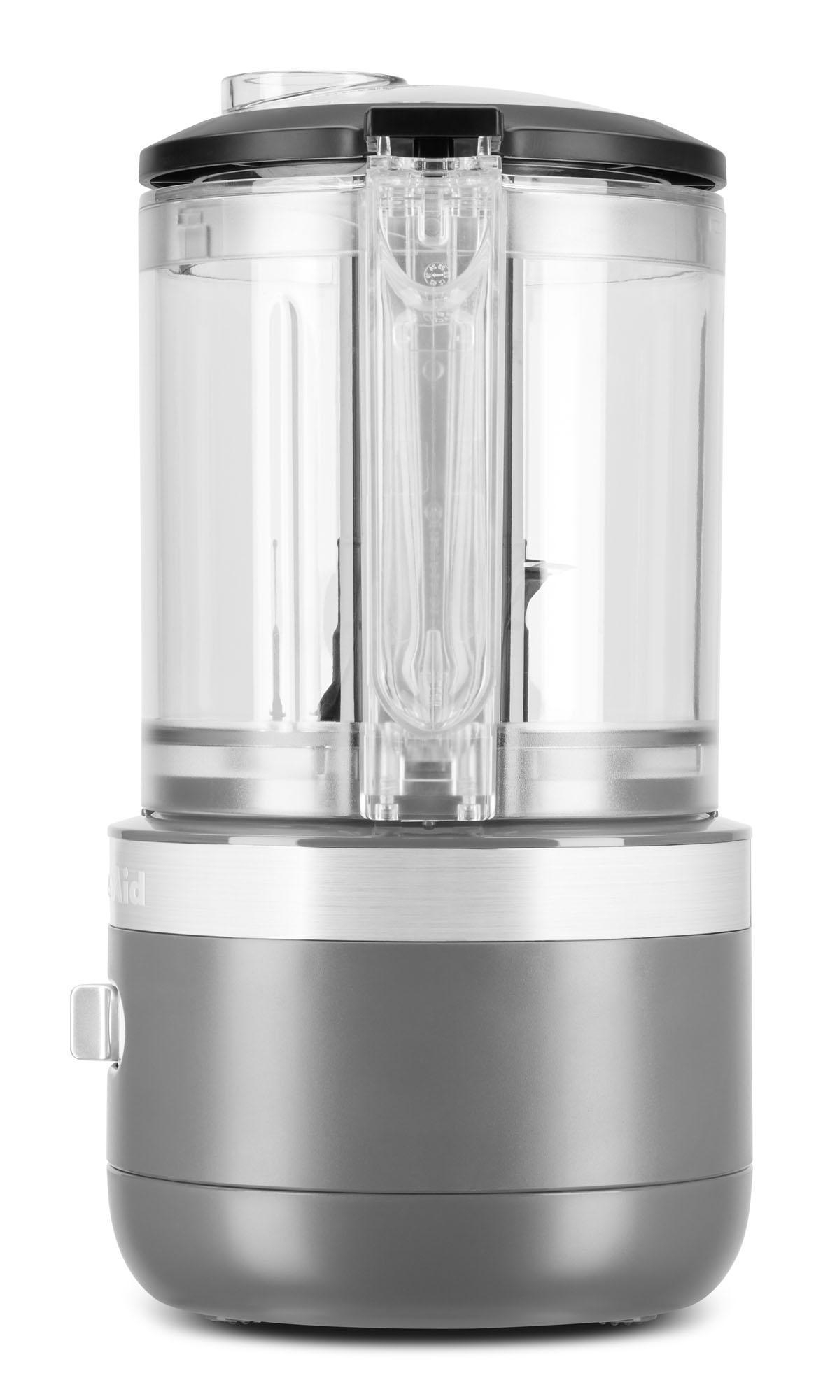 Ein grauer und klarer KitchenAid-Küchenhelfer. Die transparente Schüssel und eine schwarze Oberseite sind sichtbar.