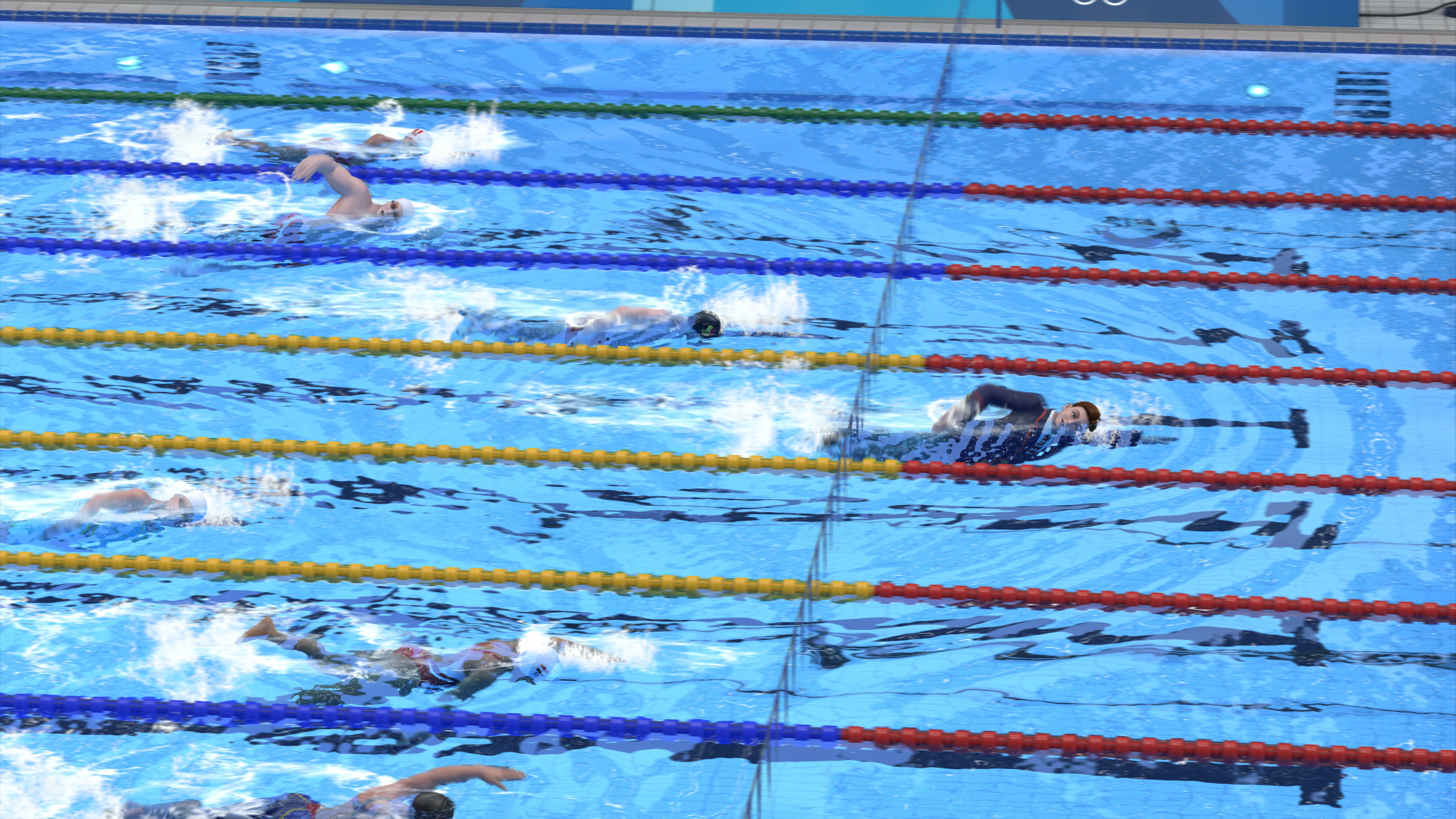 Nuotatori in una piscina nuotano verso la telecamera, con i marcatori di corsia visibili.