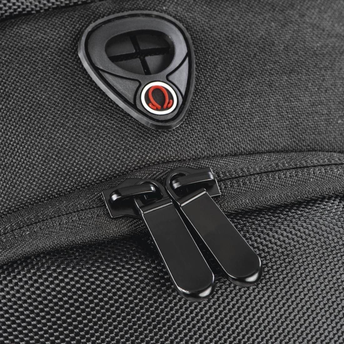 Nahaufnahme eines schwarzen Rucksacks mit zwei Reißverschlusszippern und einem Logo-Patch.