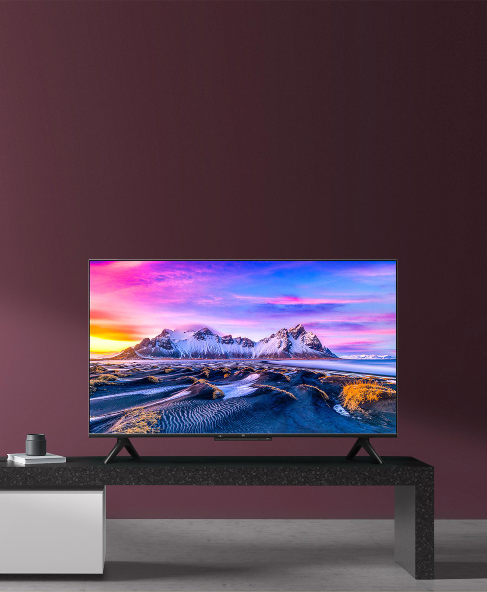 Ein Fernseher, der eine farbenfrohe Landschaftsszene zeigt, auf einem schwarzen Ständer.