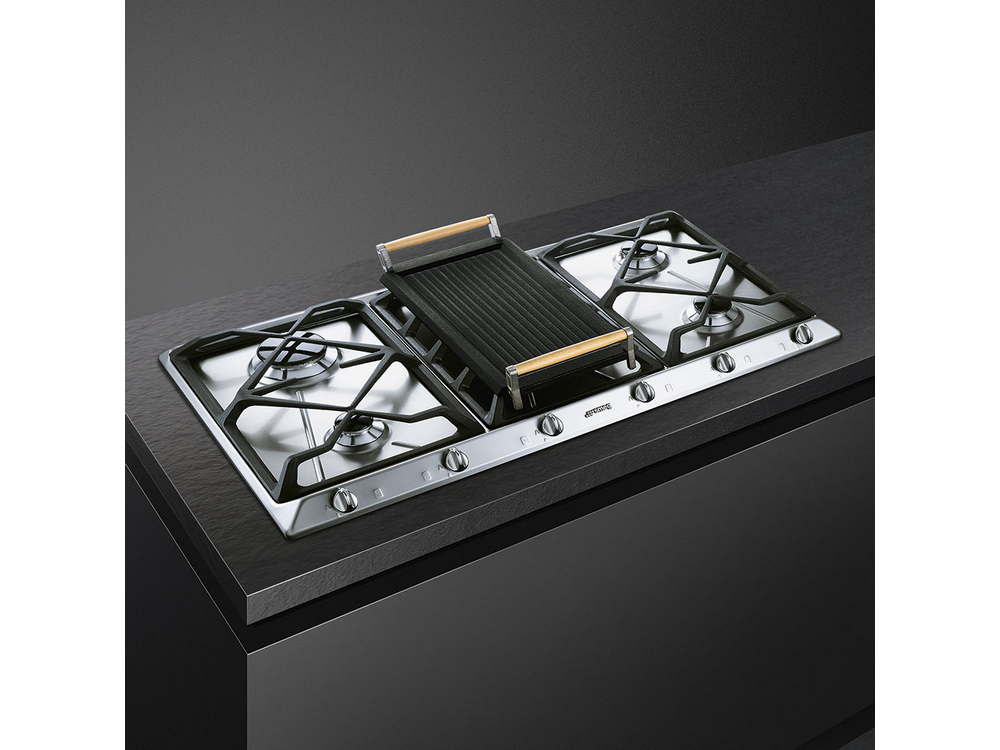 Encimera Smeg de acero inoxidable con una plancha encima.