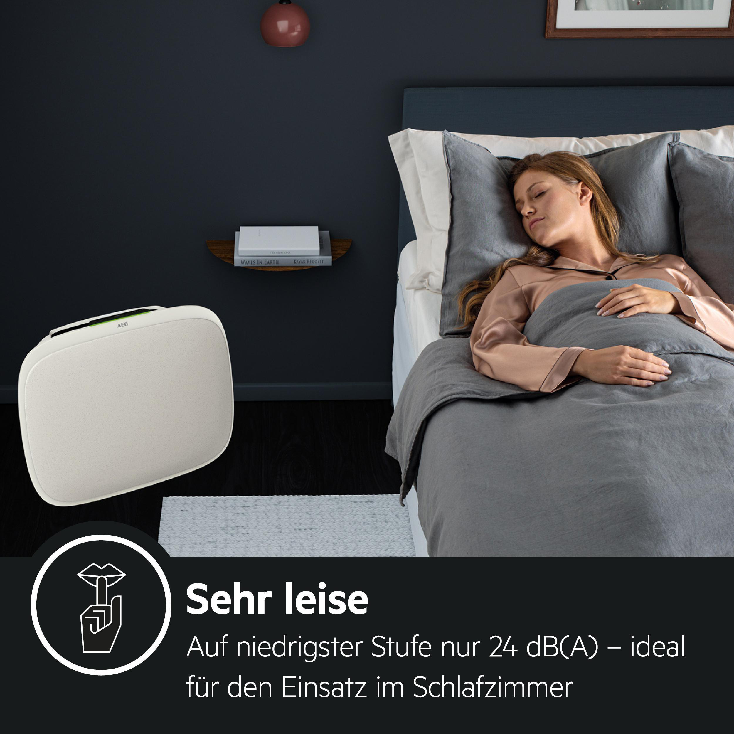 Eine Frau schläft in einem Bett, mit einem weißen Luftreiniger und dem Text 'Sehr leise'.