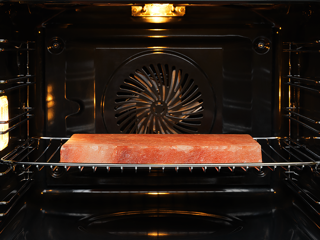 An oven interior with a red salt block on a rack. A fan is visible at the back.
