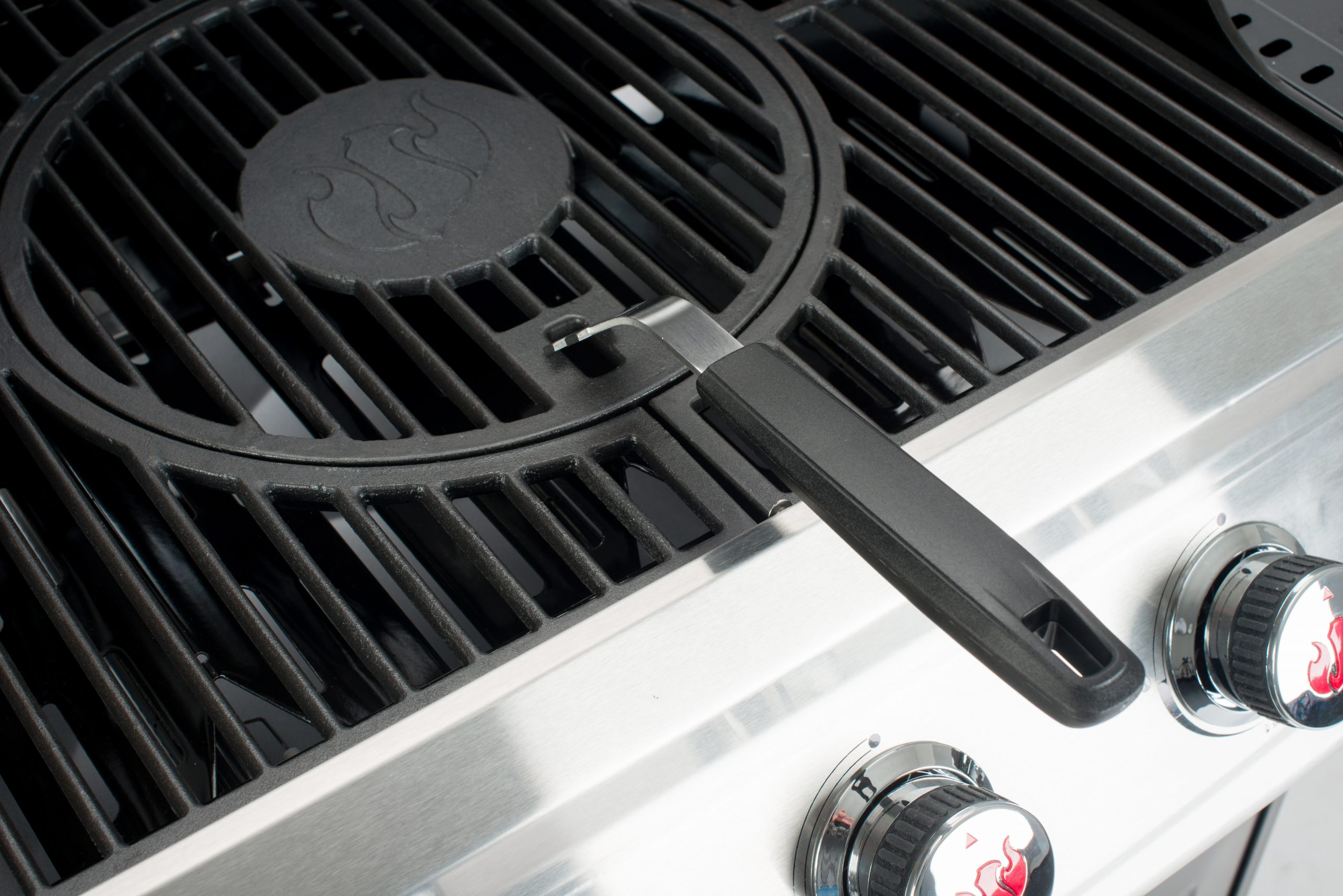 Grill felülnézete fekete rácsokkal, fogantyúval és ezüst szabályzó gombokkal.