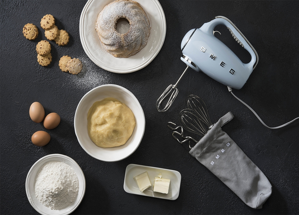 Küchenszene mit Backutensilien: Eier, Mehl, Mixer.