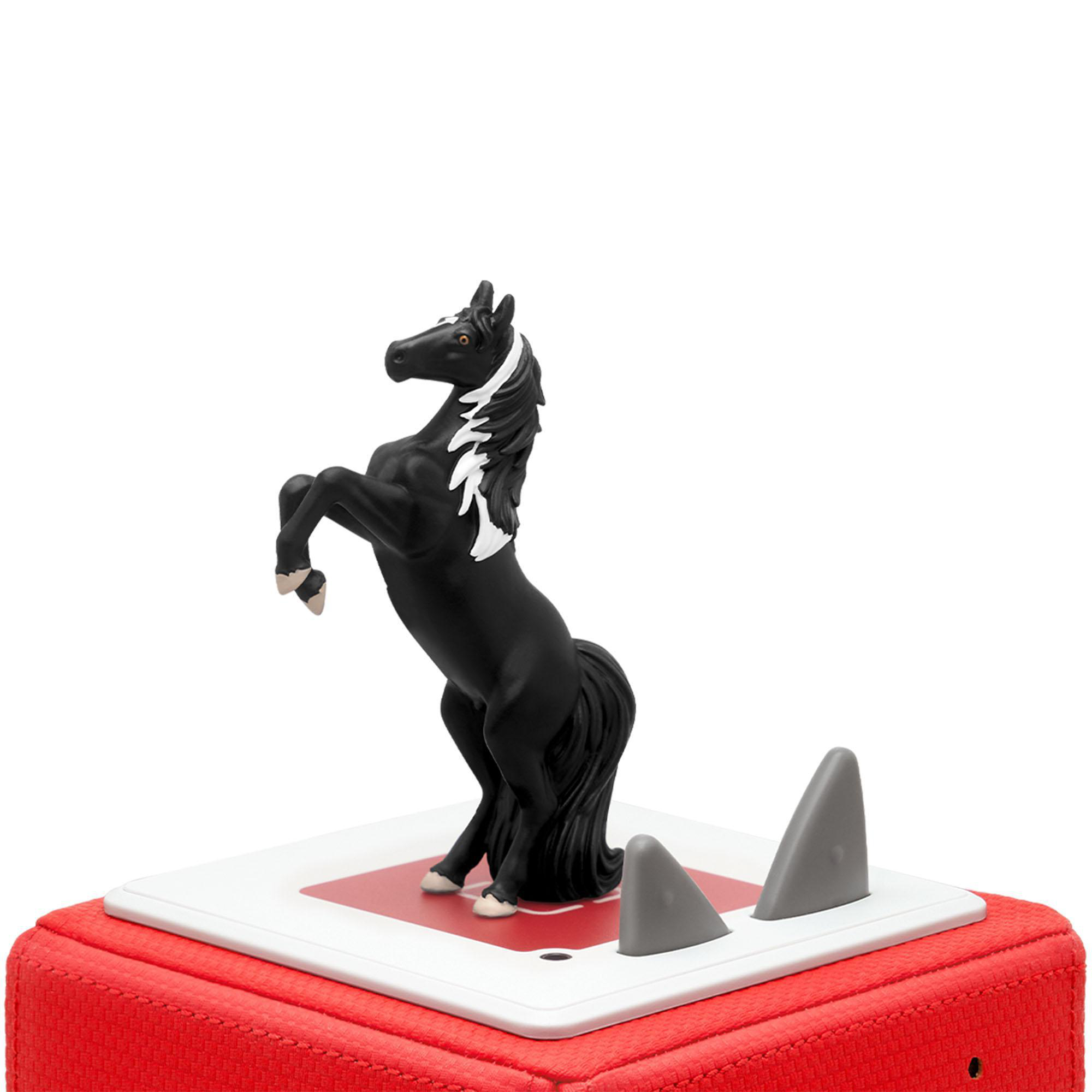 Ein schwarzes Pferdespielzeug, das auf einer roten Basis steht.