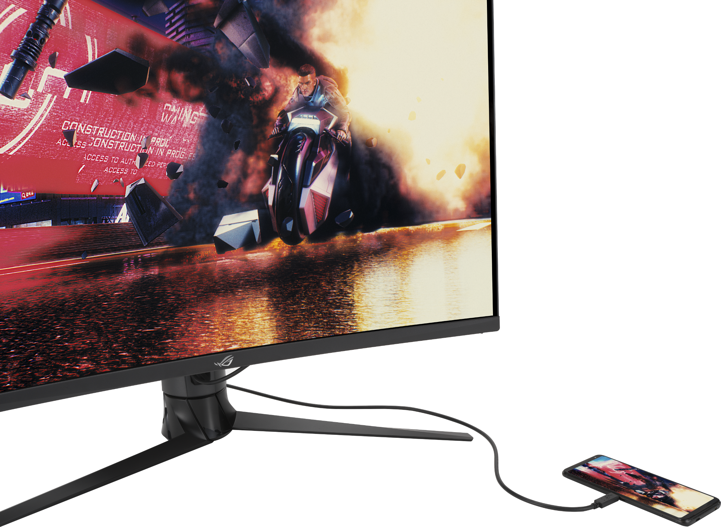 Un moniteur affiche une scène de jeu vidéo avec une moto et des explosions. Un téléphone est connecté au moniteur.
