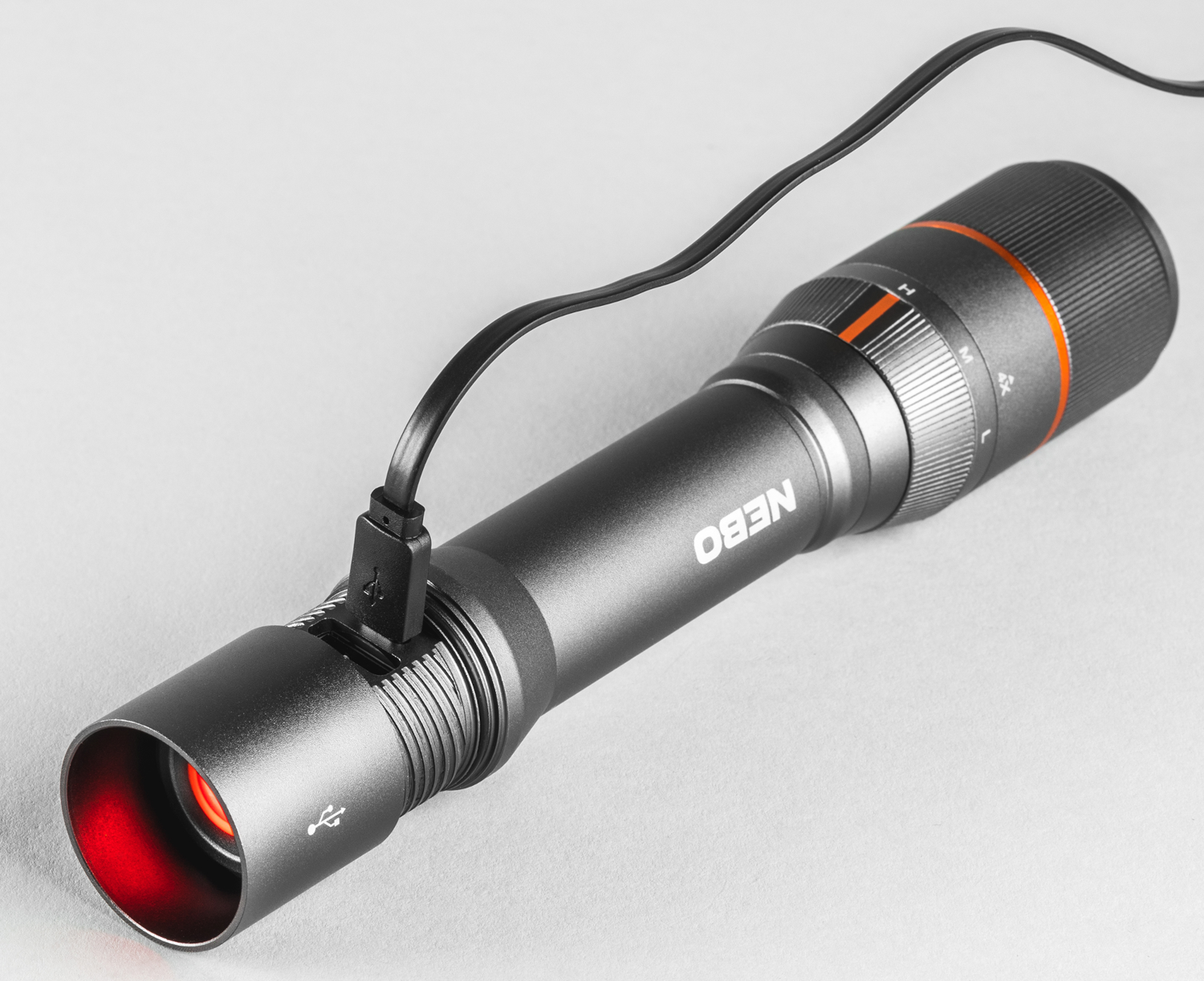 Egy fekete zseblámpa USB-porttal be van dugva. A fény piros. A márkanév NEBO.