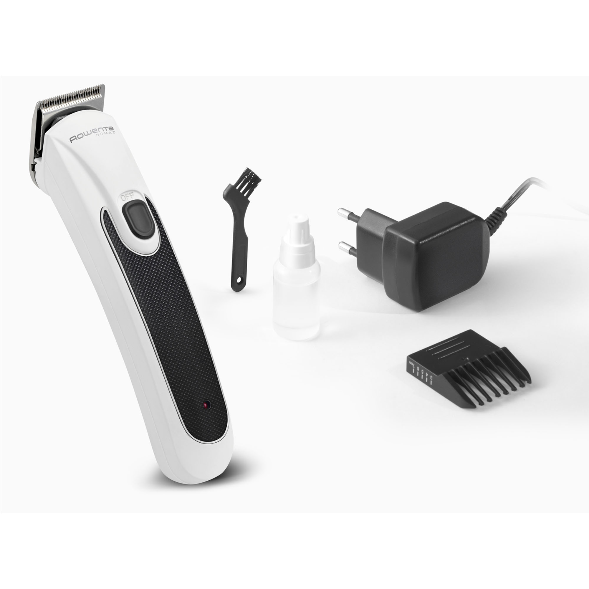 Tagliacapelli elettrico bianco con accessori. Sono visibili una spazzola, un flacone d'olio e un caricabatterie.