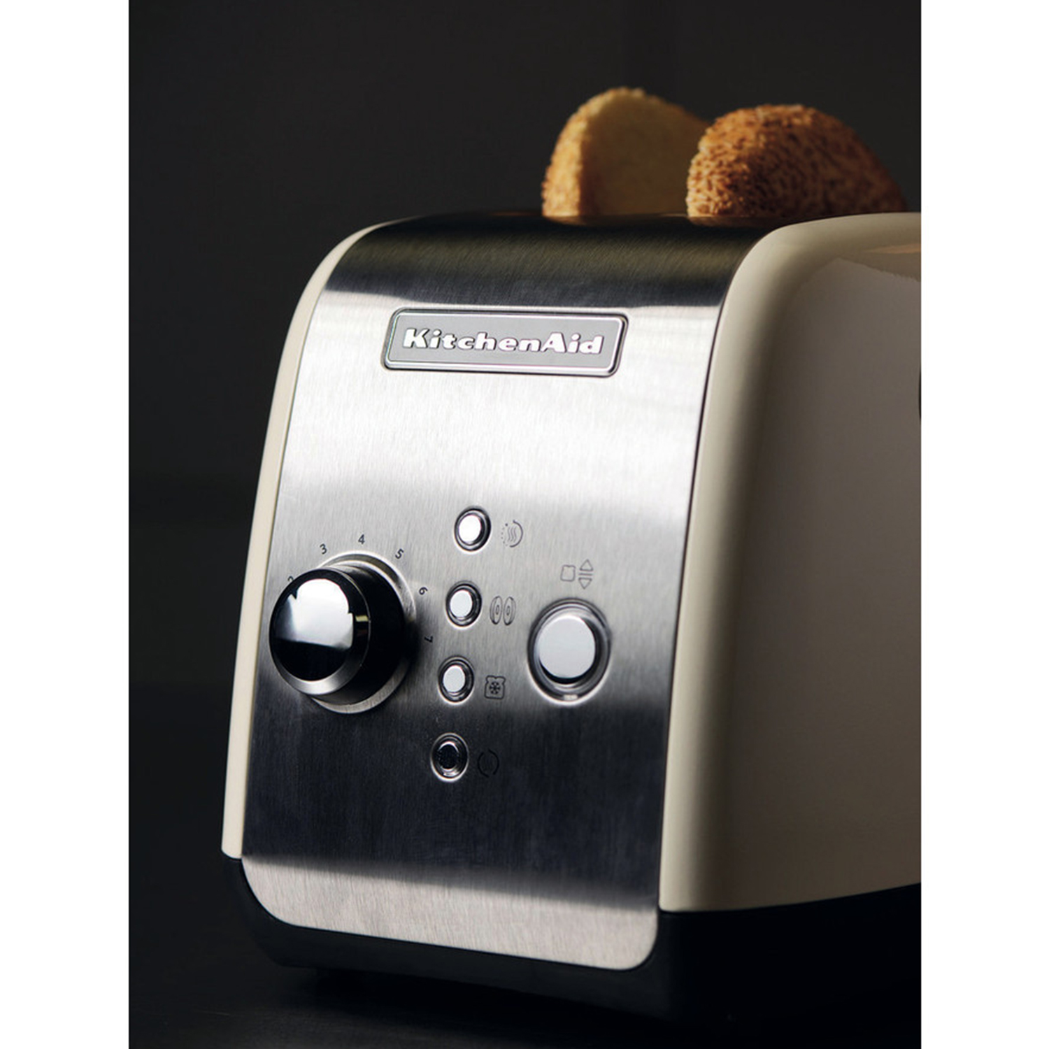 Tostapane KitchenAid color crema e argento con fette di pane nelle fessure.