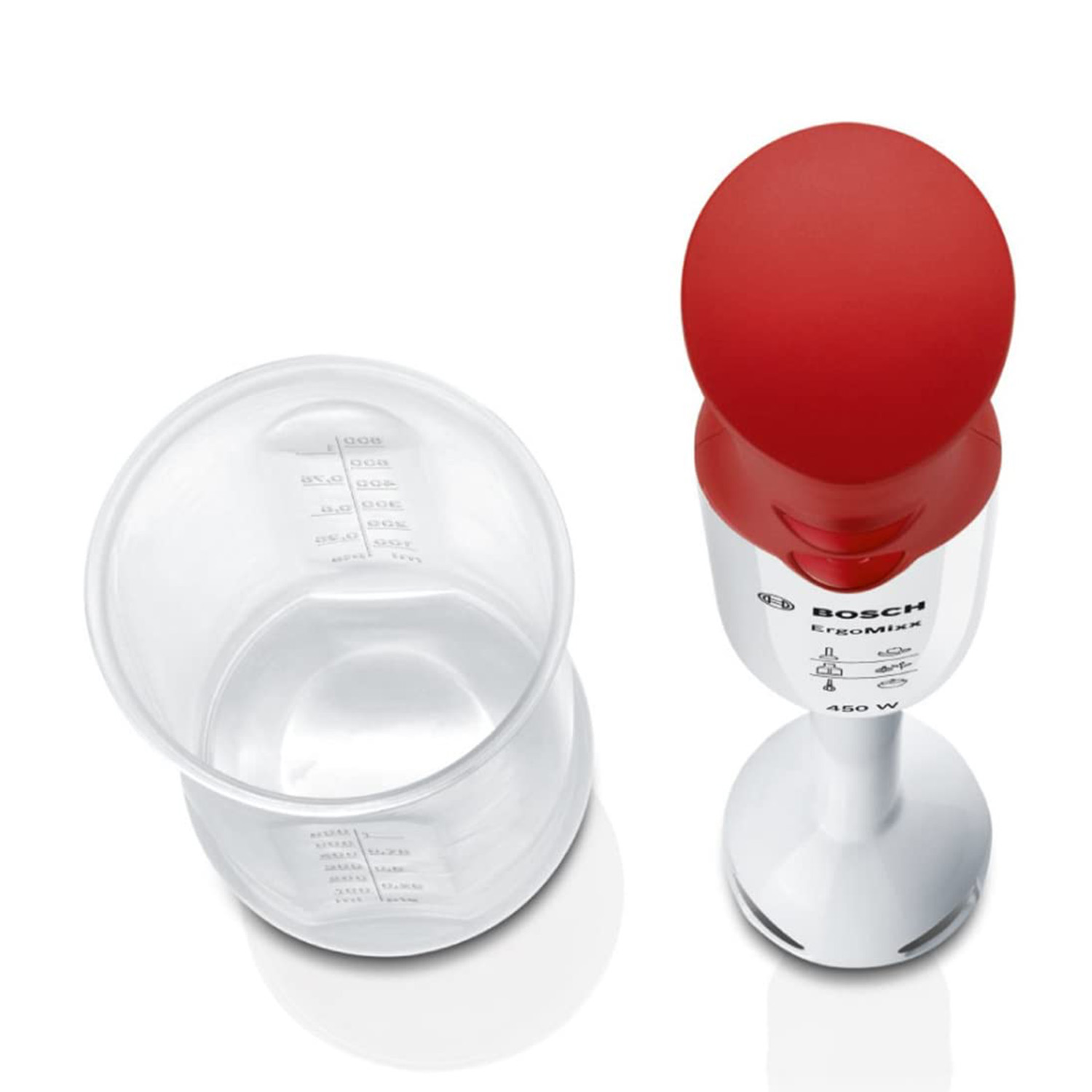 Un frullatore a immersione bianco e rosso con un misurino di plastica trasparente accanto.