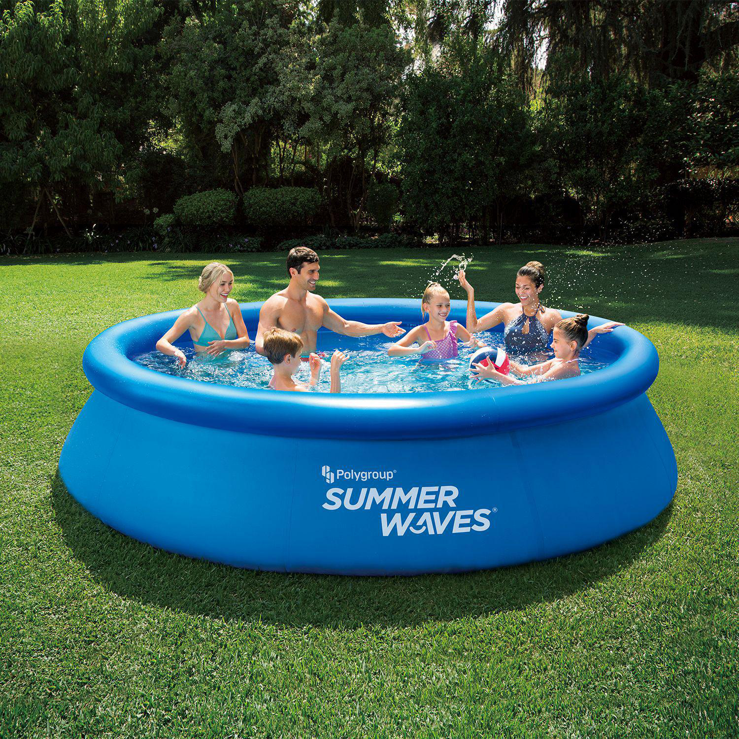 Familie in einem blauen aufblasbaren Pool auf grünem Gras. Leute spritzen Wasser, sonniger Tag.