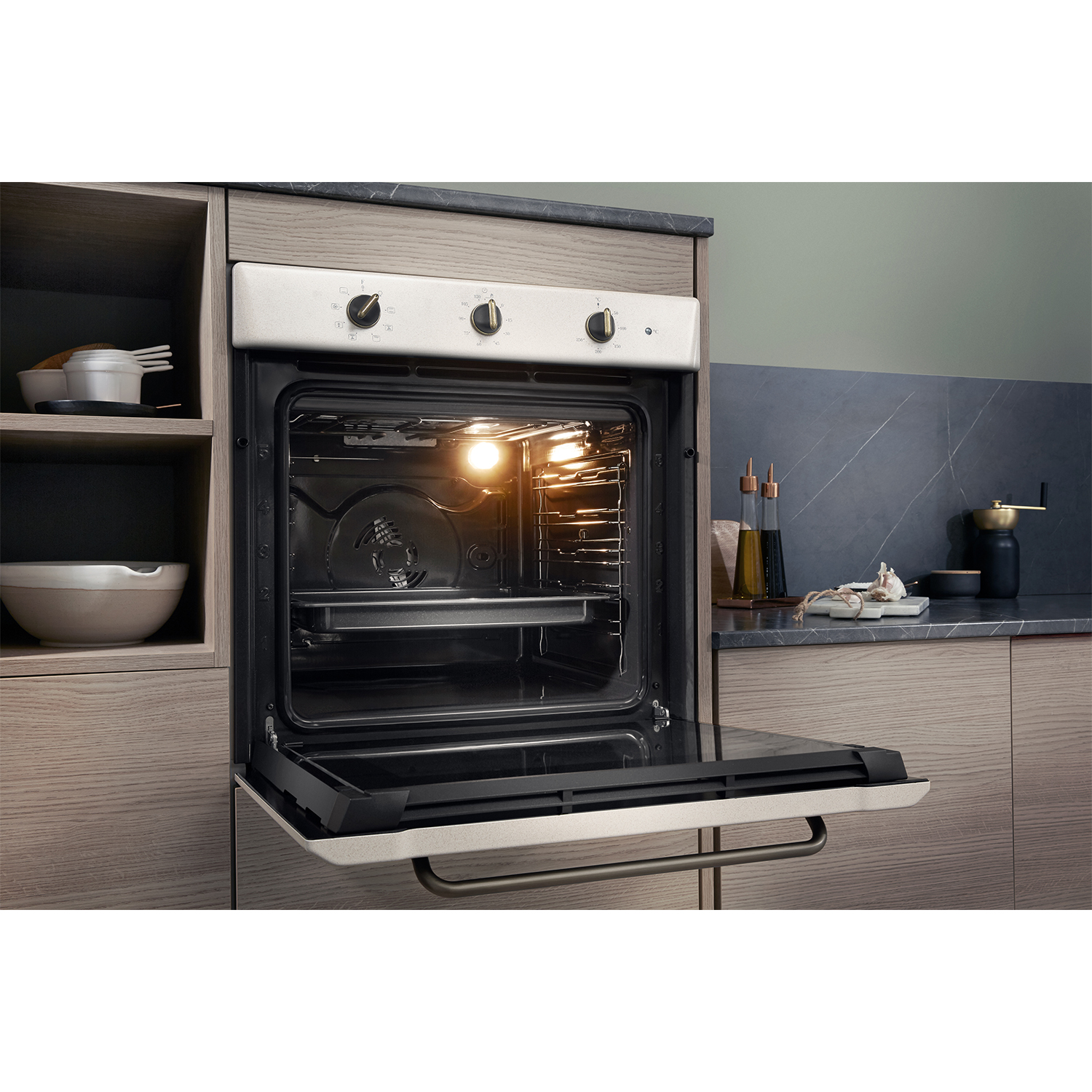 Forno aperto in una cucina. La luce interna è accesa. Mobile in legno e piano scuro visibili.