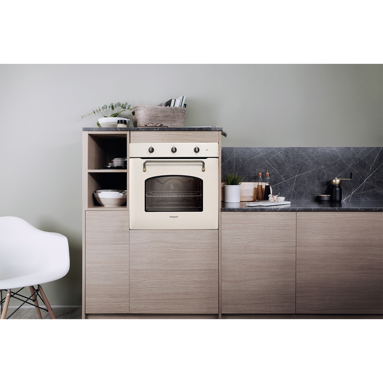 Forno beige in un mobile di legno. Ambiente cucina con sedia e decorazioni.