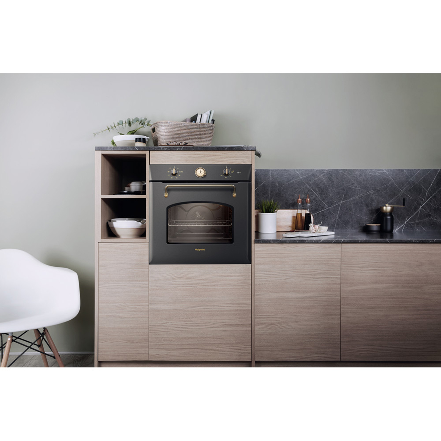 Un forno integrato in un mobile di legno con un piano di lavoro nero. Il forno è nero con una maniglia dorata.
