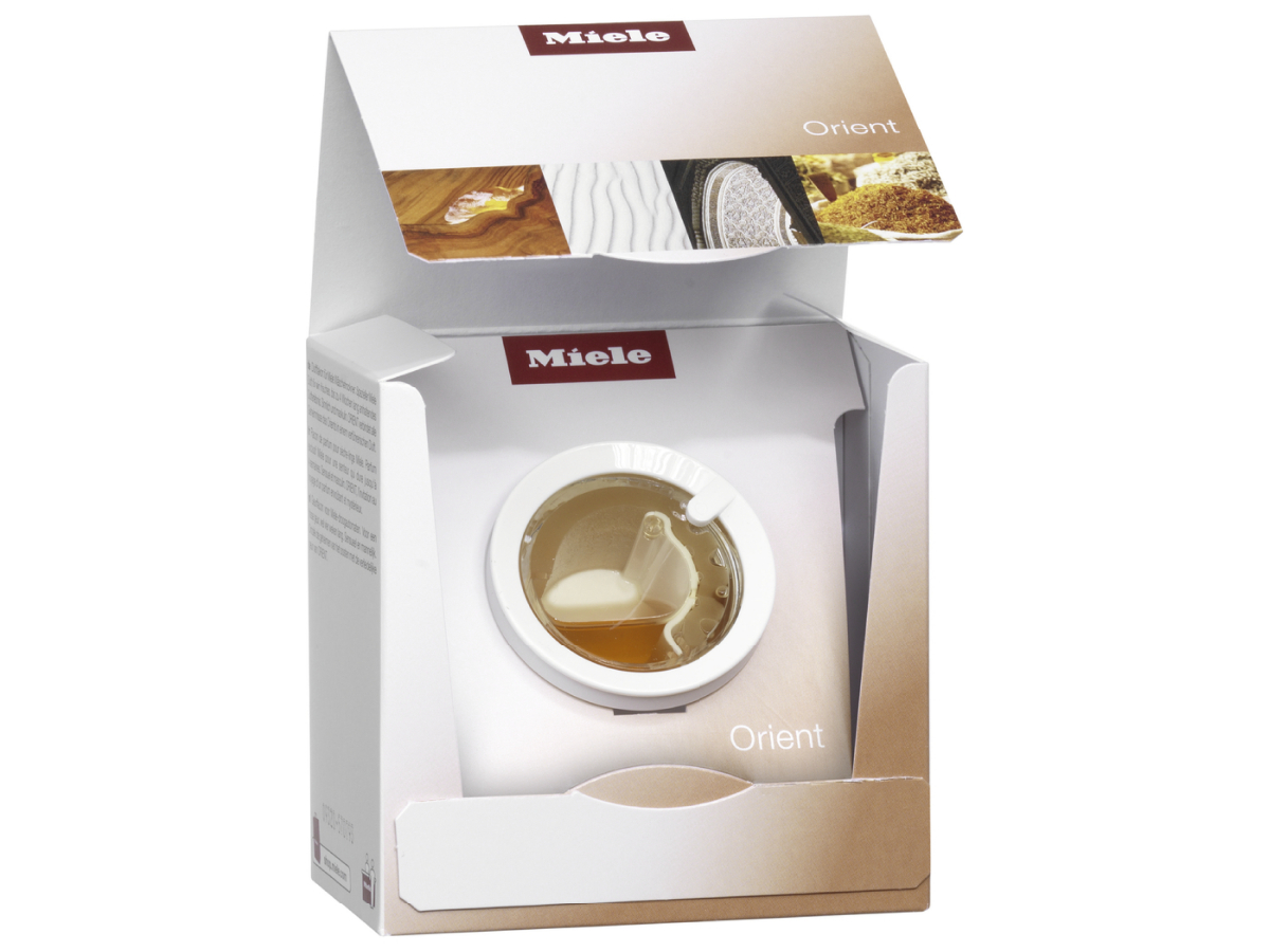 Box with a washing machine inside. The top of the box is open. Miele brand name visible.
