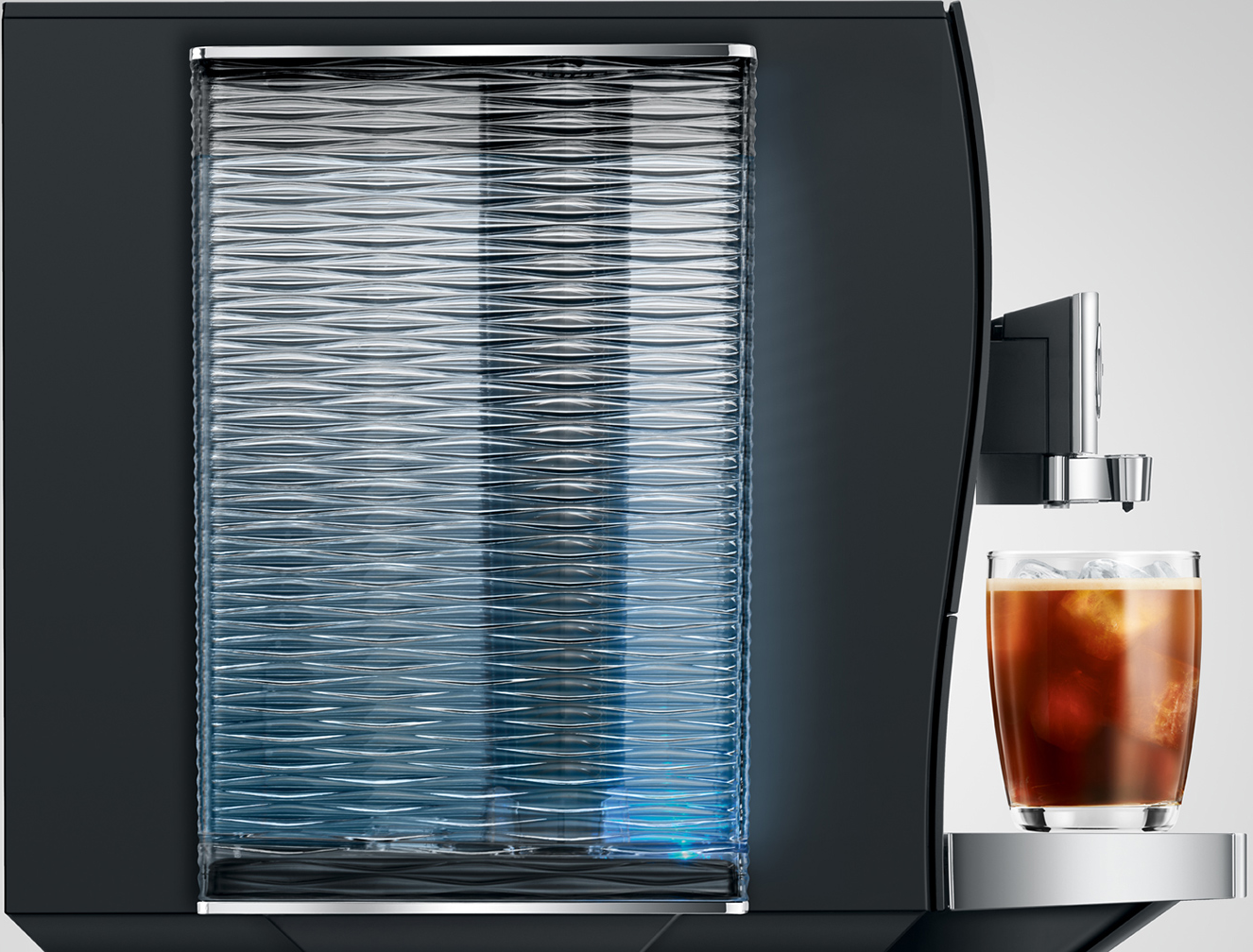 Macchina da caffè nera con serbatoio dell'acqua in vetro e un bicchiere di caffè freddo.