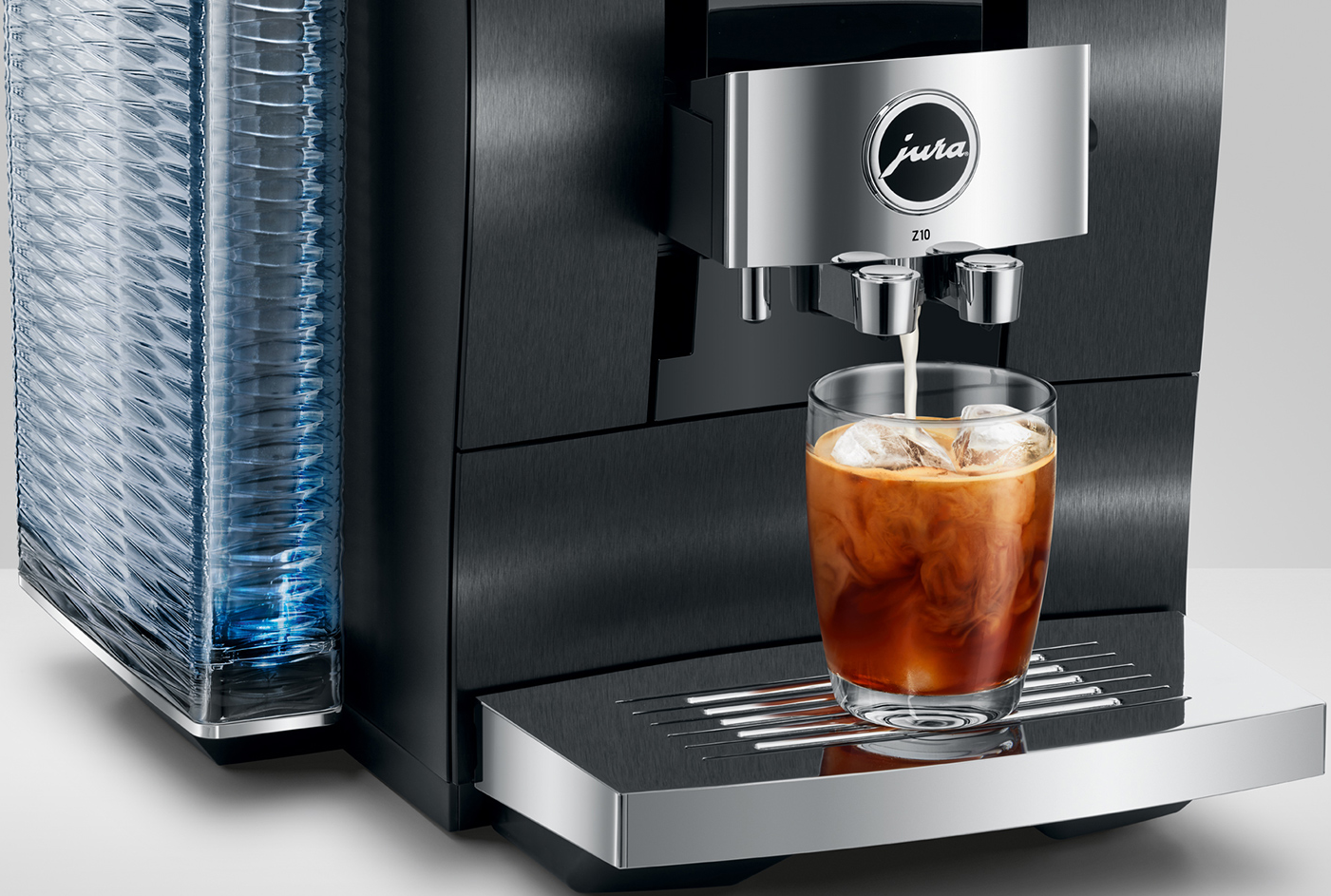 Una macchina da caffè Jura Z10 che eroga caffè in un bicchiere con ghiaccio. Primo piano.
