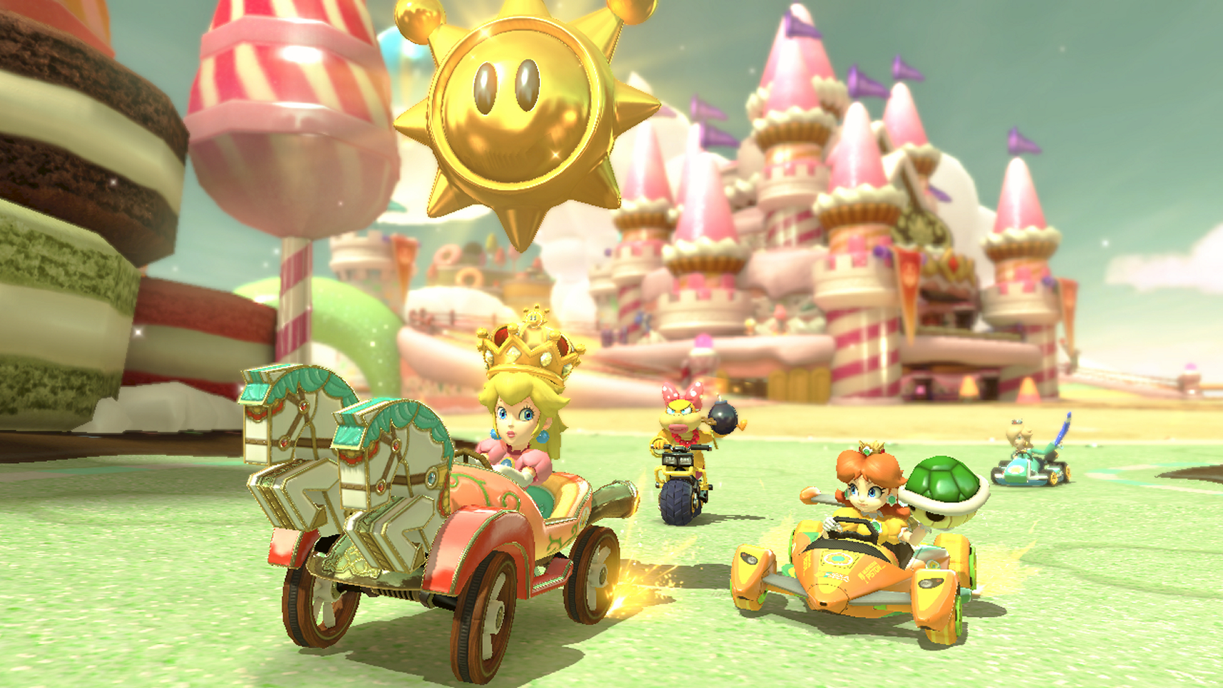 Scena del gioco Mario Kart con personaggi che corrono in kart su una pista colorata. L'ambientazione è un paese di caramelle.