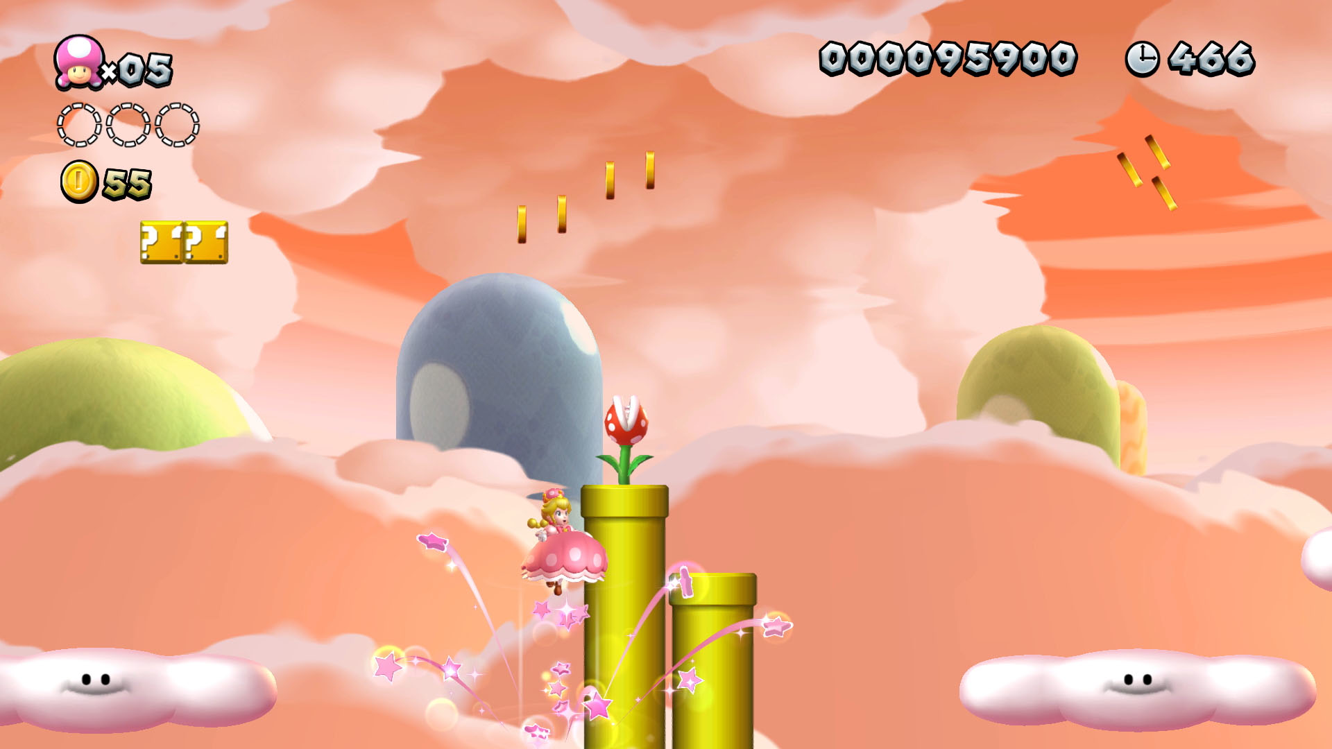 Una scena del gioco di Mario con Mario su un tubo, nuvole, monete e una pianta piranha in un cielo rosa.