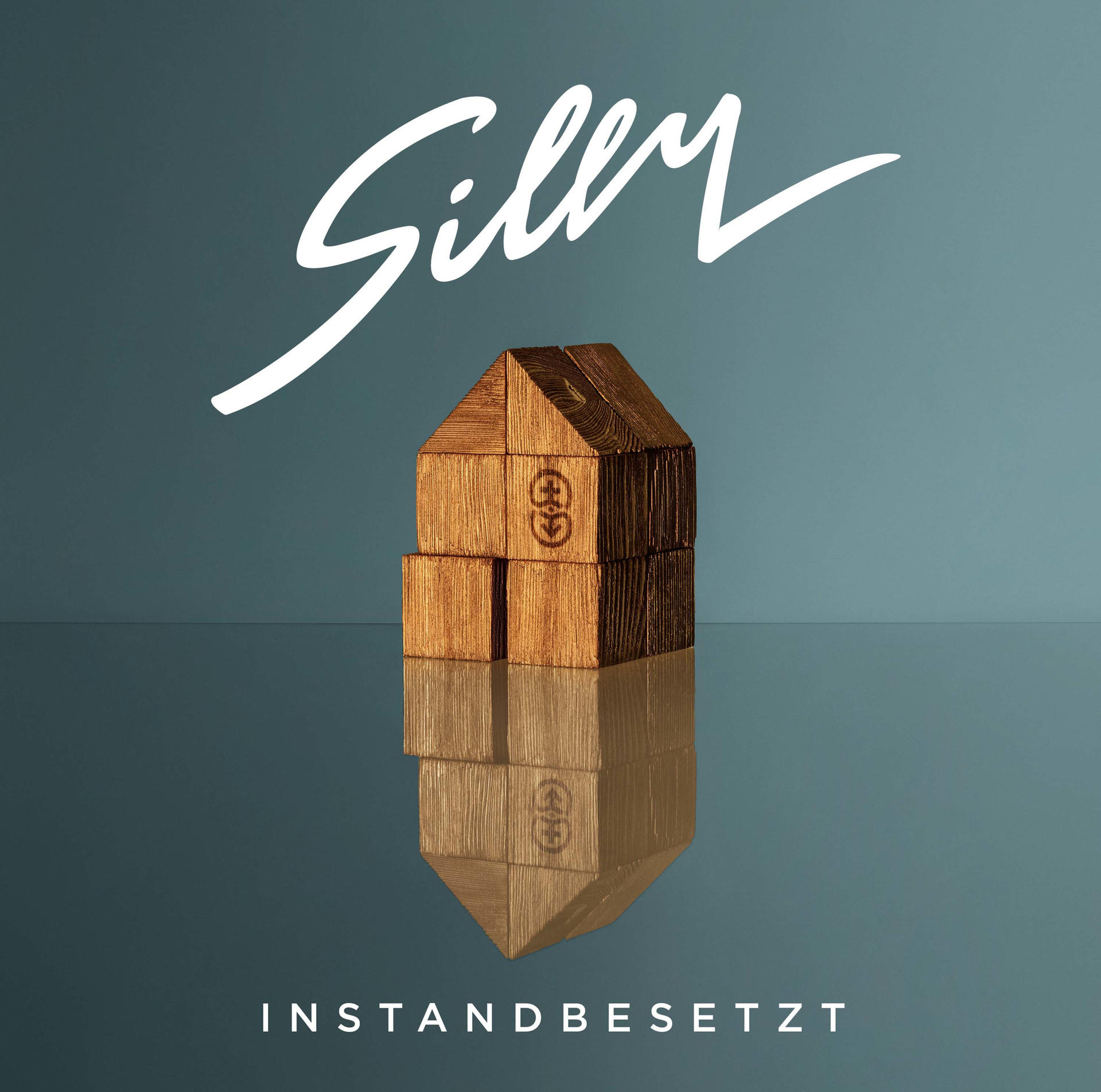 Holzhausblöcke mit dem Wort 'Silly' darüber und 'Instandbesetzt' darunter, auf einer reflektierenden Oberfläche.
