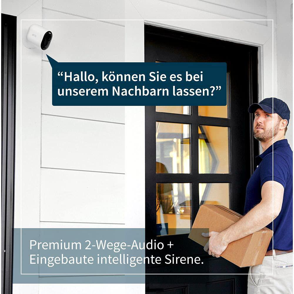 Eine Person vor einem Haus hält eine Box, eine Überwachungskamera in der oberen linken Ecke und Text auf Deutsch.