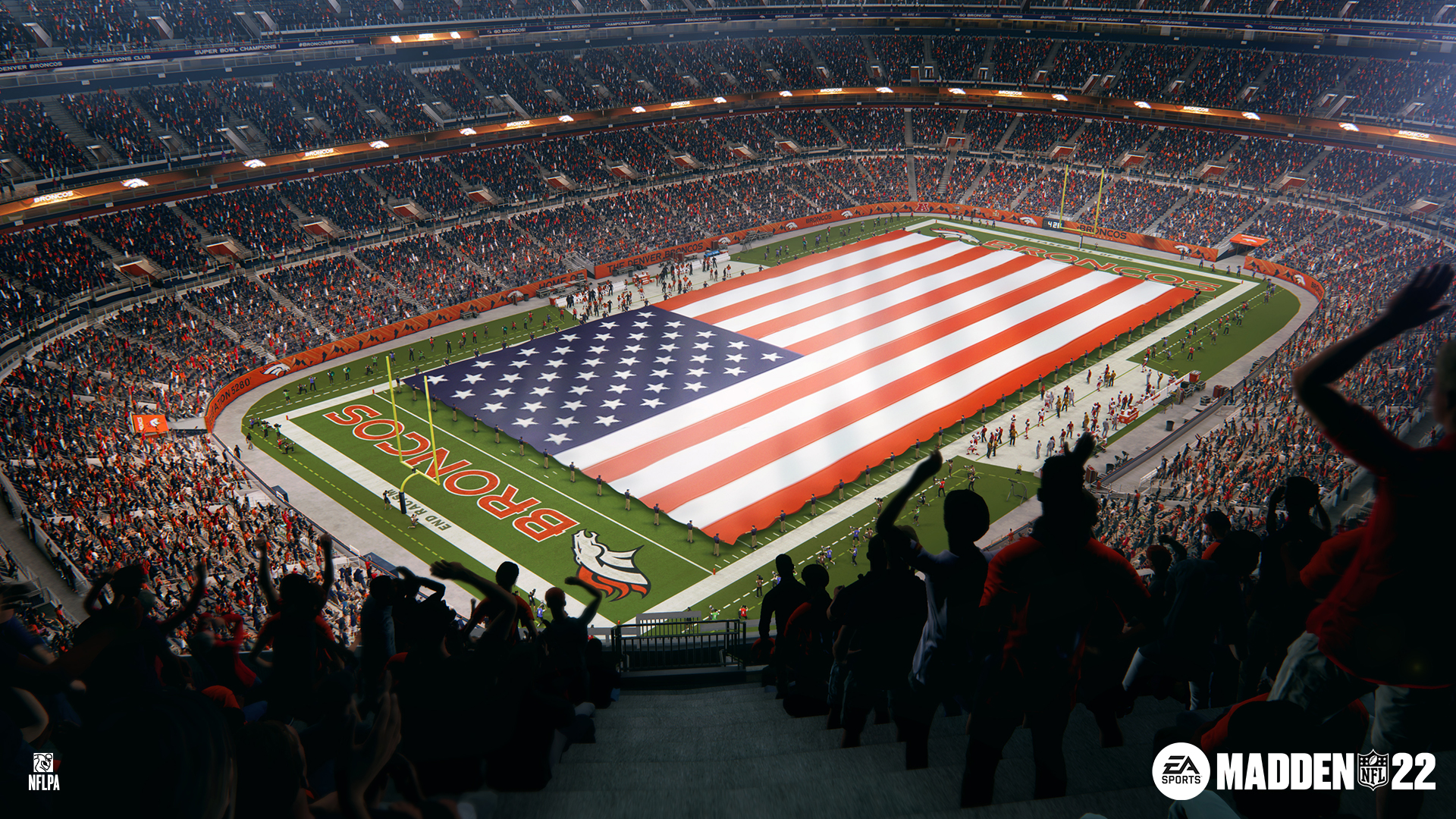 Ein Footballfeld mit riesiger amerikanischer Flagge und Fans auf den Rängen.