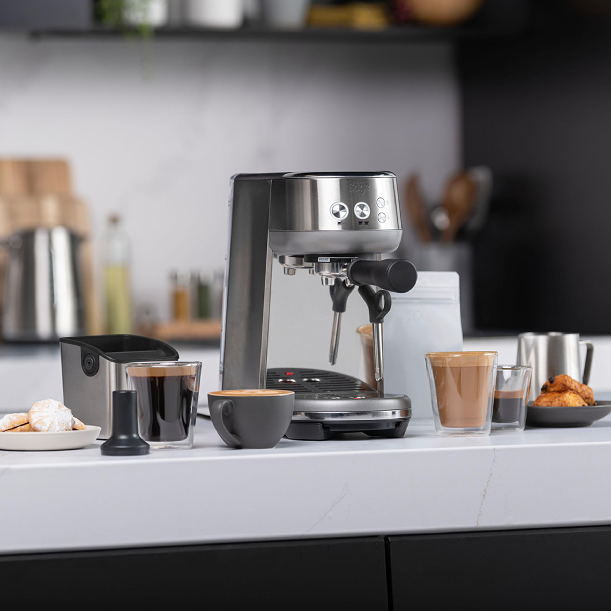 Eine Kaffeemaschine mit Tassen und Zubehör auf einer Theke.