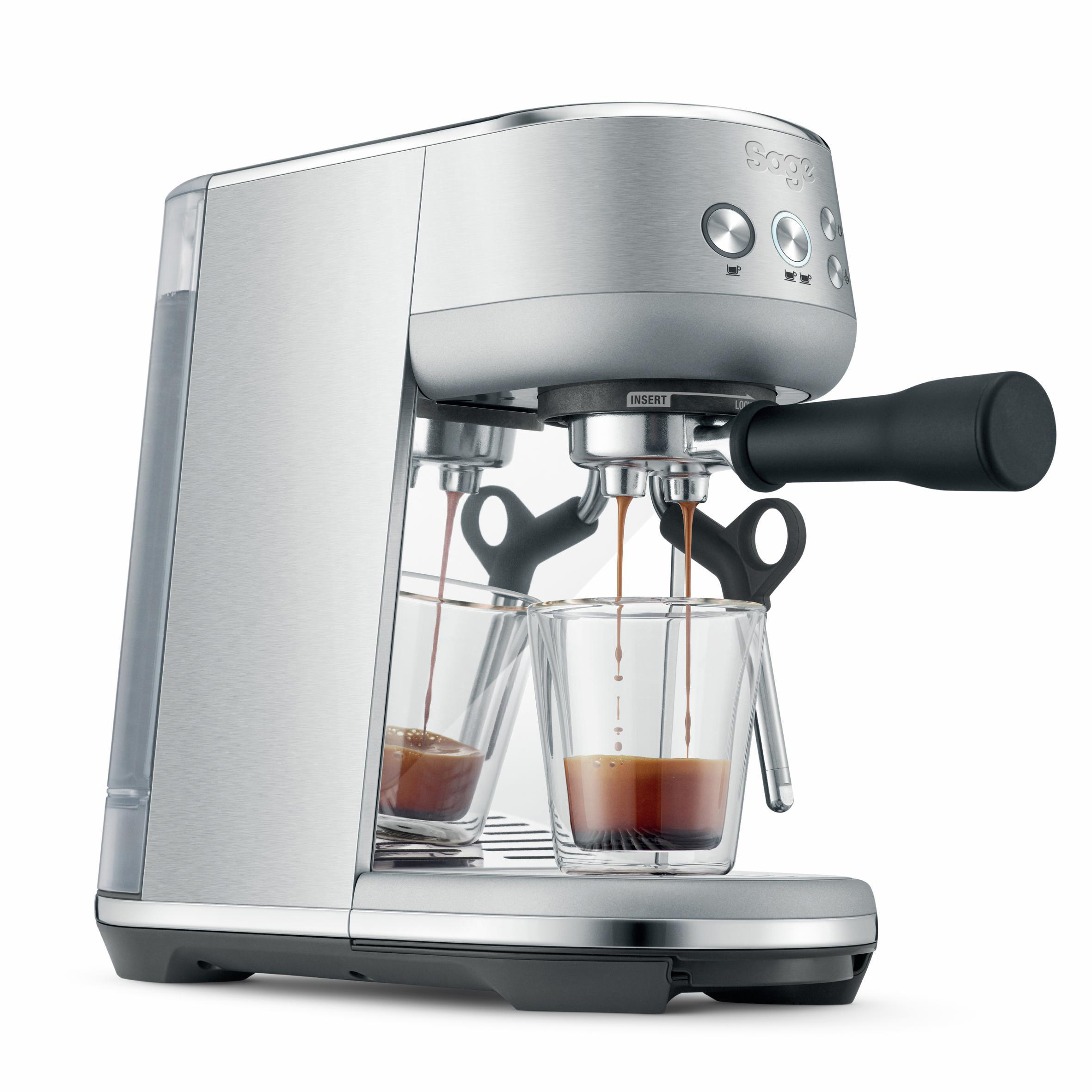 Eine silberne Espressomaschine mit zwei mit Kaffee gefüllten Gläsern. Schwarze Details und weißer Hintergrund.