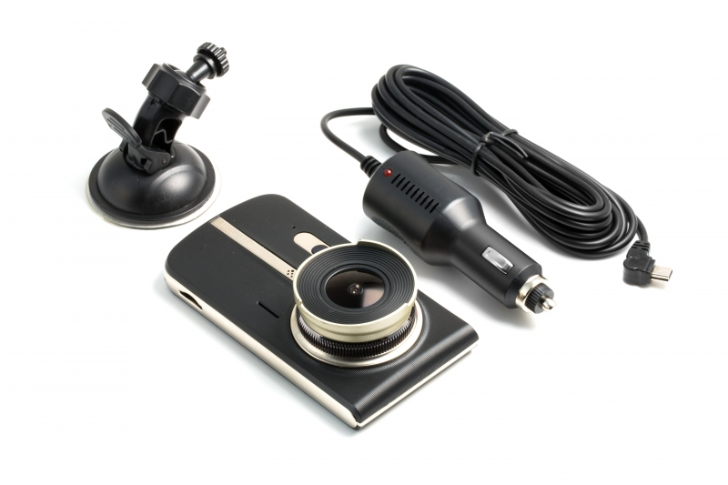 Dashcam-Set: Kamera, Saugnapfhalterung, Autoladegerät und Kabel. Weißer Hintergrund.