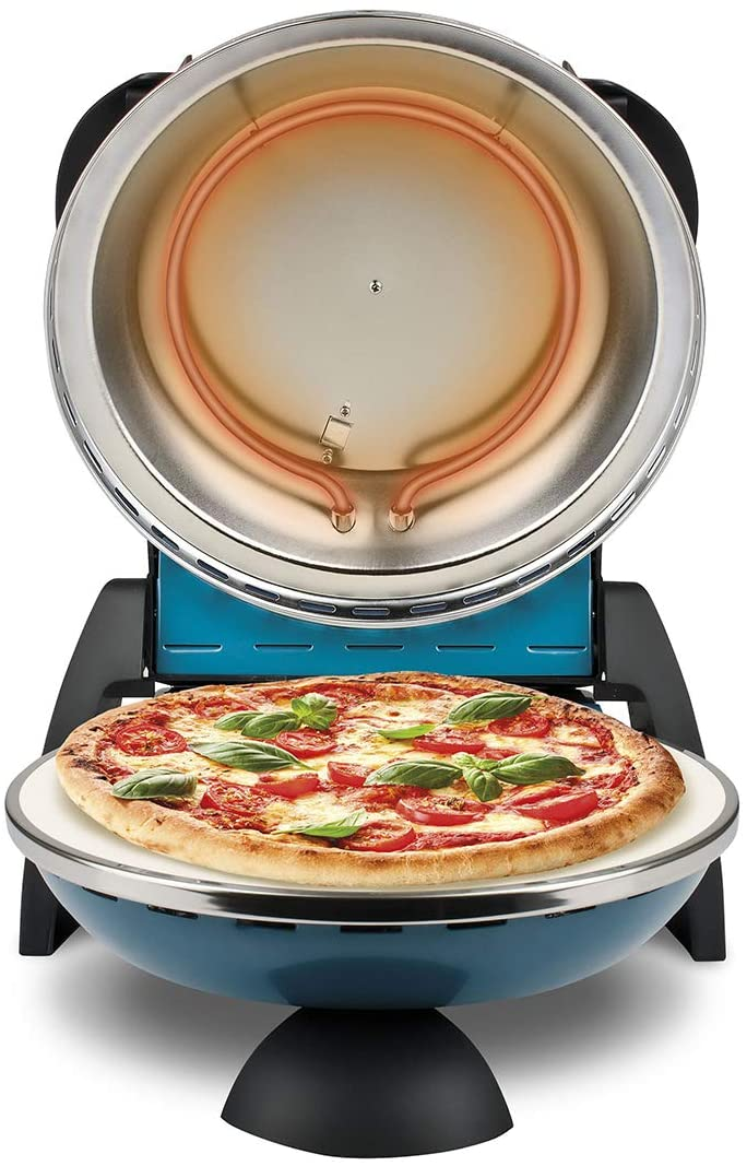 Eine Pizza liegt in einem blauen Pizzaofen. Die Pizza hat Tomaten und Basilikum. Der Ofendeckel ist geöffnet und zeigt Heizelemente.