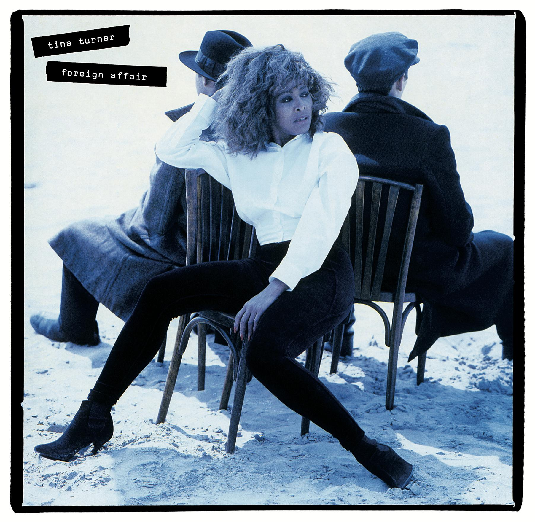 Albumcover von Tina Turners 'Foreign Affair'. Tina Turner auf einem Stuhl, zwei Männer im Hintergrund, Blauton.