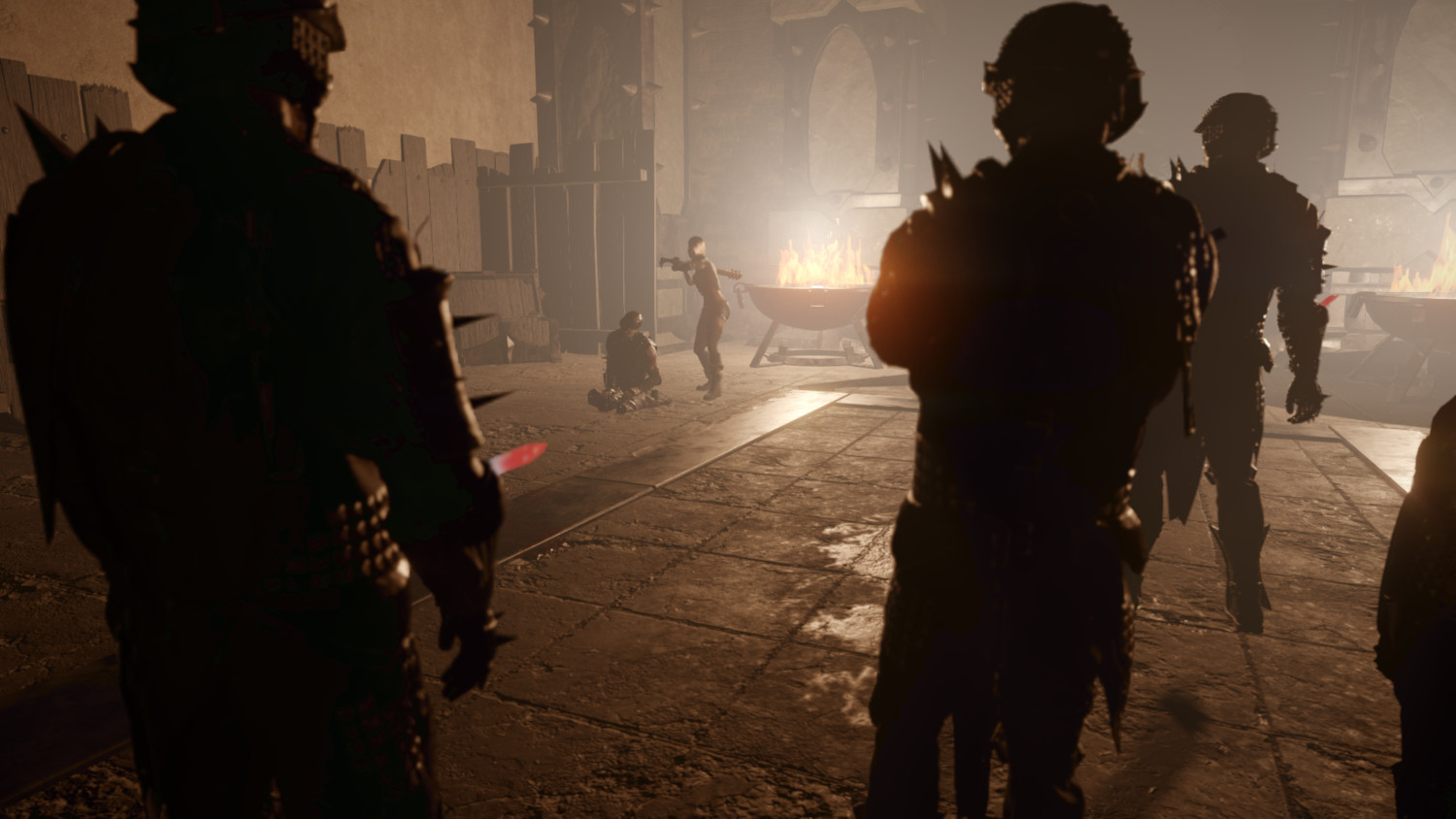 Une scène sombre avec des silhouettes, un feu et une personne étant ciblée avec une arme.