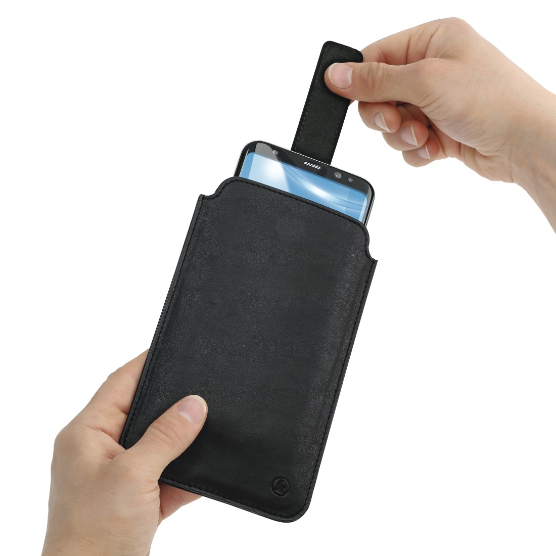 Ein schwarzes Telefon wird von zwei Händen in eine schwarze Leder-Telefonschutzhülle gelegt.
