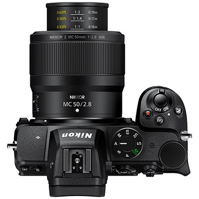 Draufsicht einer schwarzen Kamera mit Objektiv. Nikon-Logo sichtbar. Verschiedene Knöpfe.