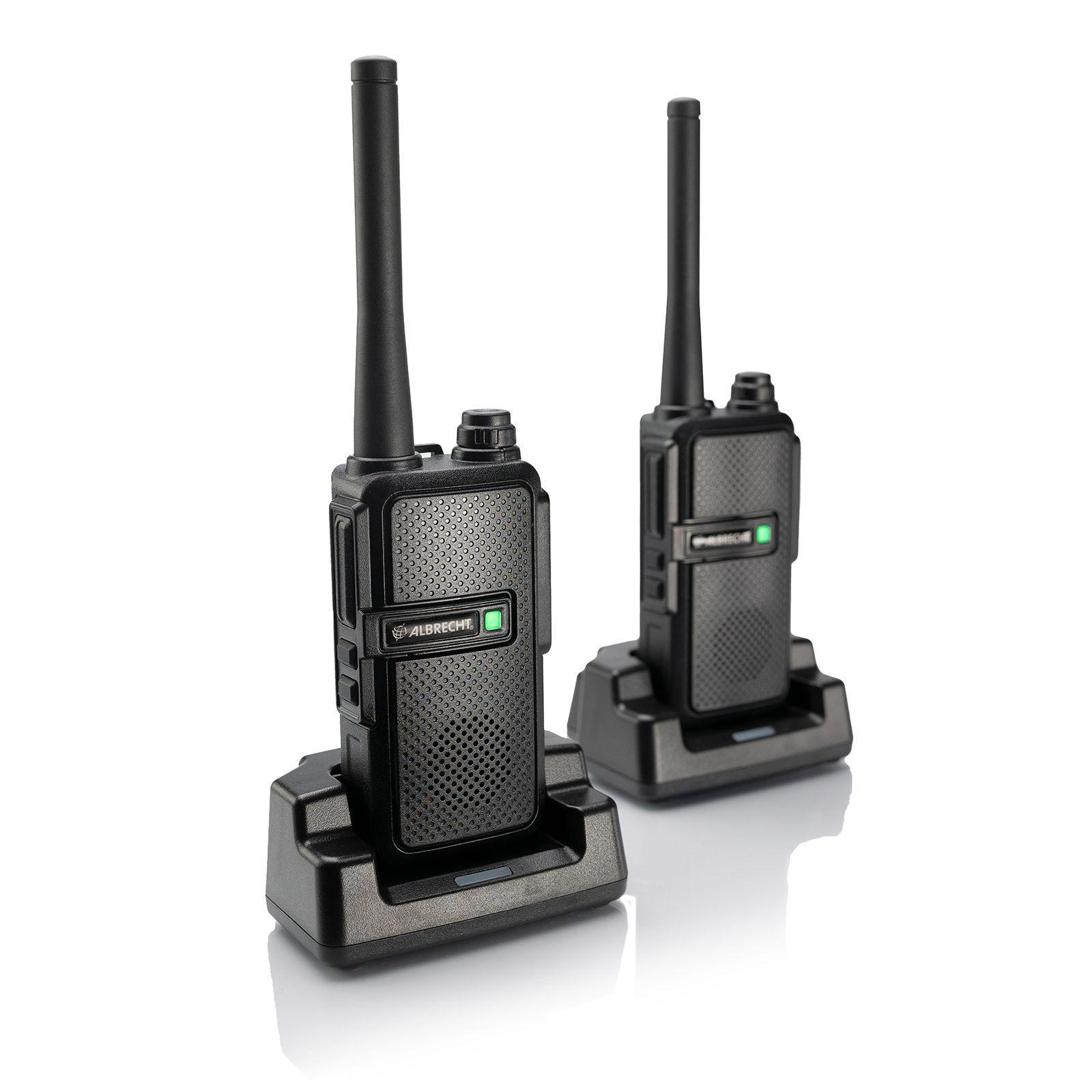Zwei schwarze Walkie-Talkies mit Antennen in Ladestationen auf weißer Oberfläche.