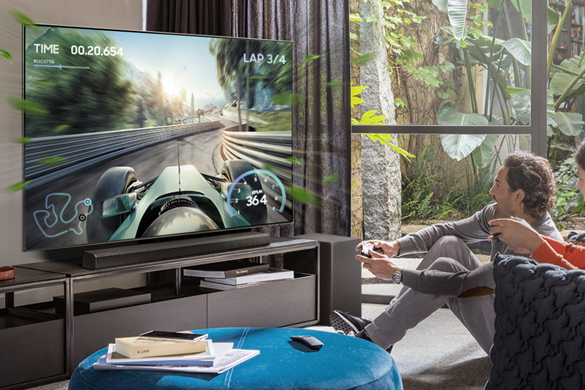 Hombre jugando videojuegos en TV. Carrera de Fórmula 1 en pantalla. Barra de sonido en primer plano.